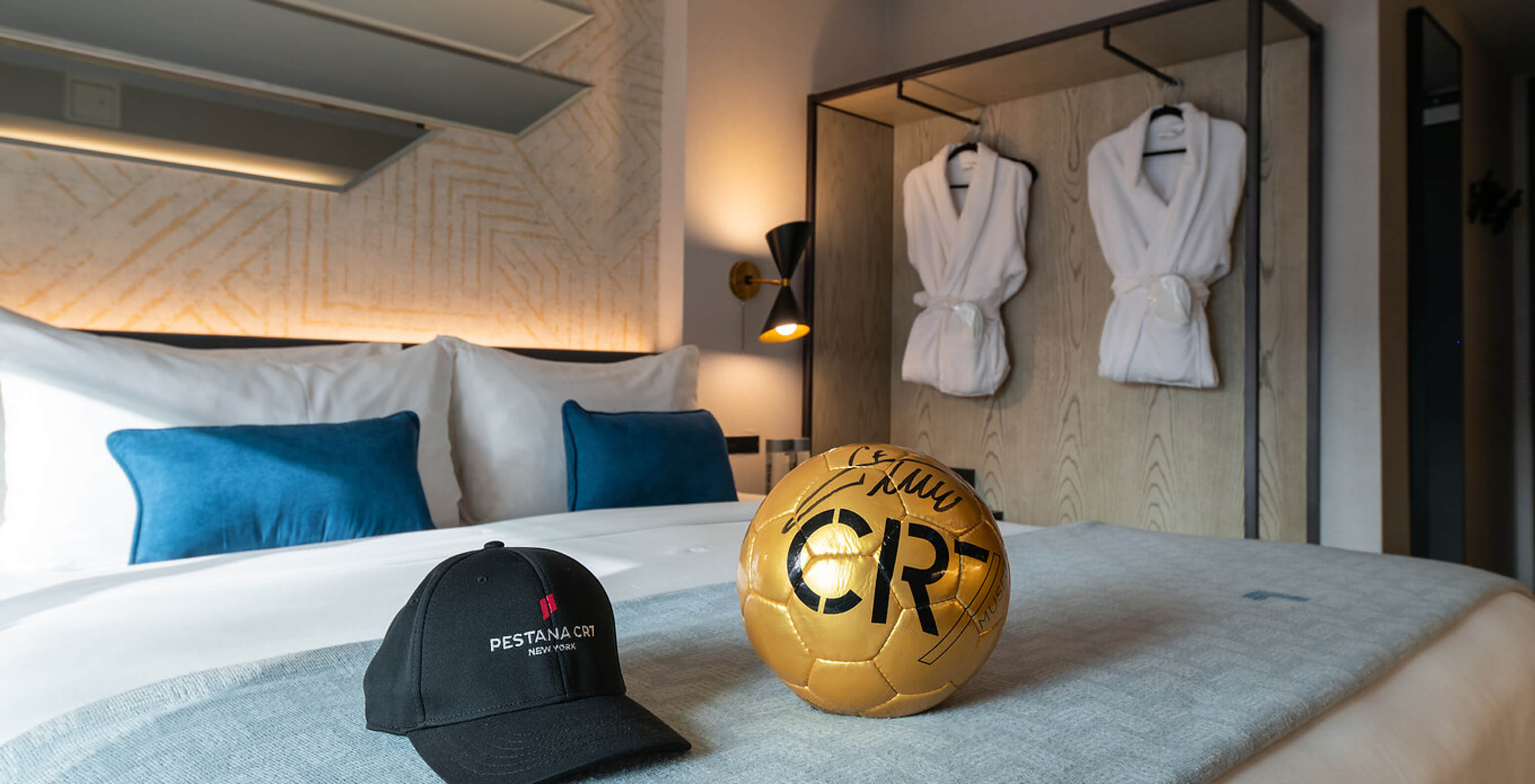 Das Deluxe King Room ADA im Pestana CR7 Times Square hat ein Doppelbett mit einem CR7-Ball und einem Hut