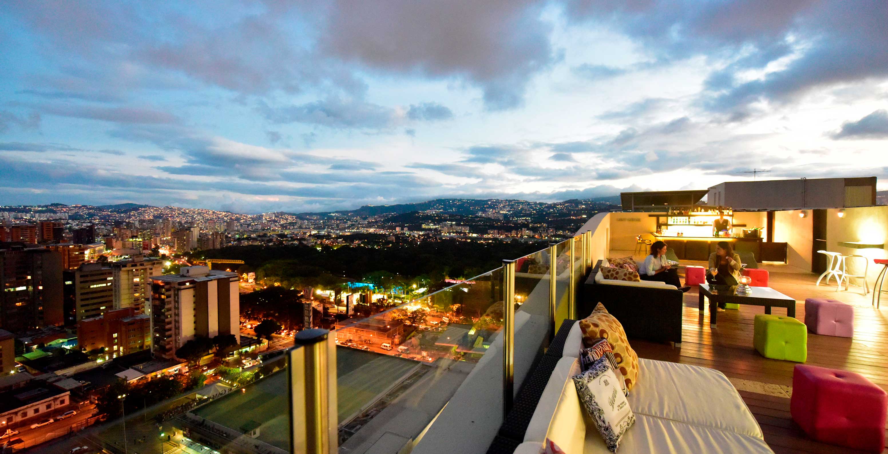 Restaurant bei Sonnenuntergang im Rooftop des Hotels in Caracas, nahe dem Finanzviertel, mit Sofas und Blick auf die Stadt