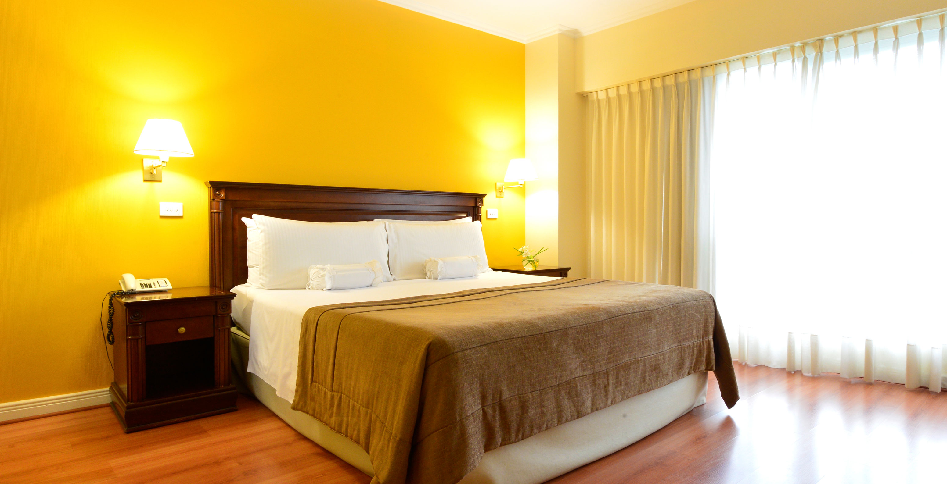 The Queen Deluxe Room at Pestana Buenos Aires has a double bed and a bedside table with a lamp