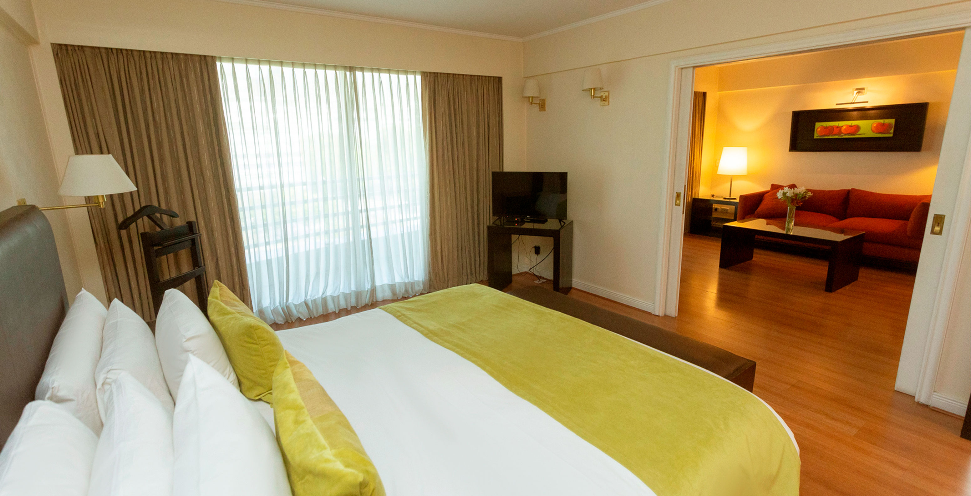 The Queen Suite at Pestana Buenos Aires has a double bed, lamp, TV, and sofa