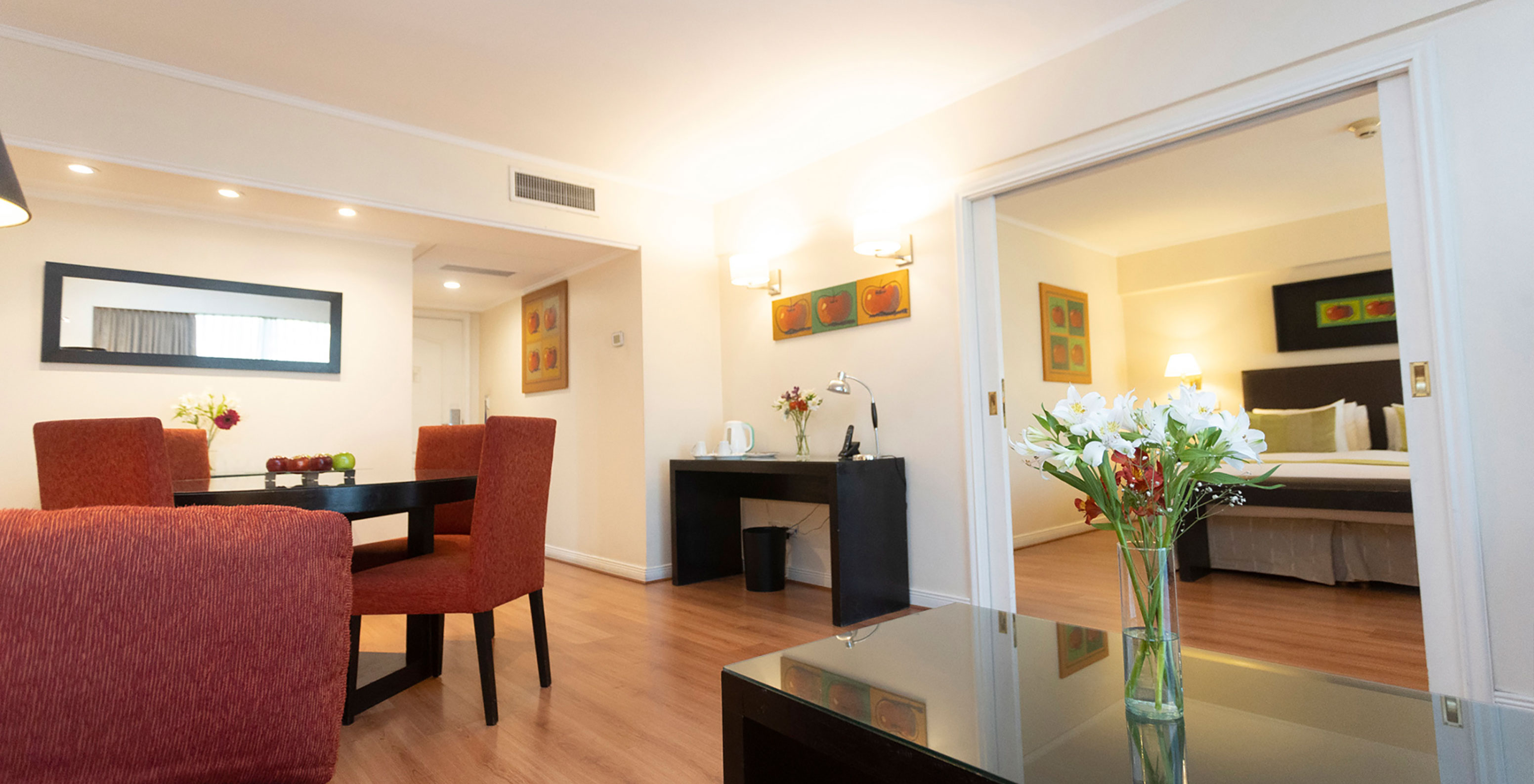 The Queen Suite at Pestana Buenos Aires has a table with chairs, a mirror, phone, and coffee table