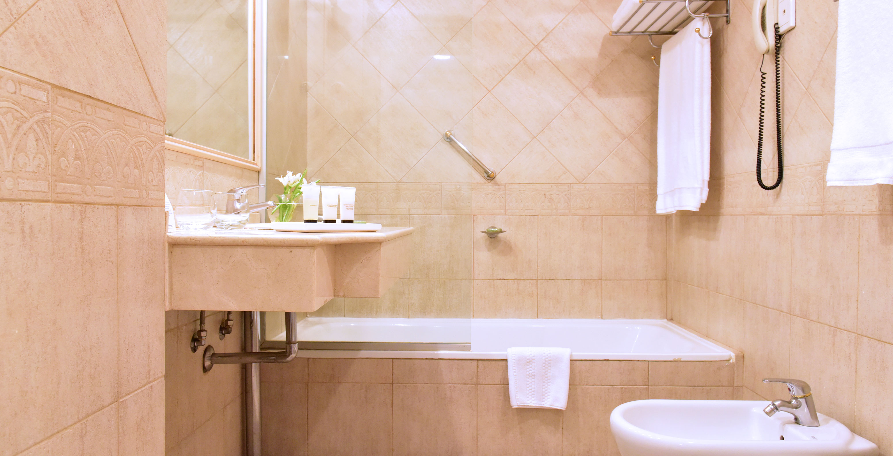 The Twin Deluxe Room at Pestana Buenos Aires has a bathroom with a sink, mirror, and a bathtub with a shower