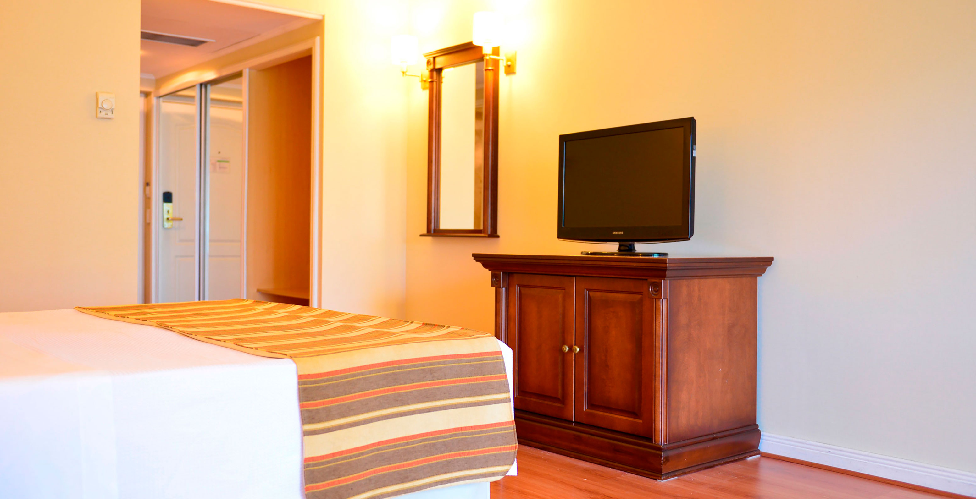 The Twin Deluxe Room at Pestana Buenos Aires has a TV, wardrobe, and a mirror