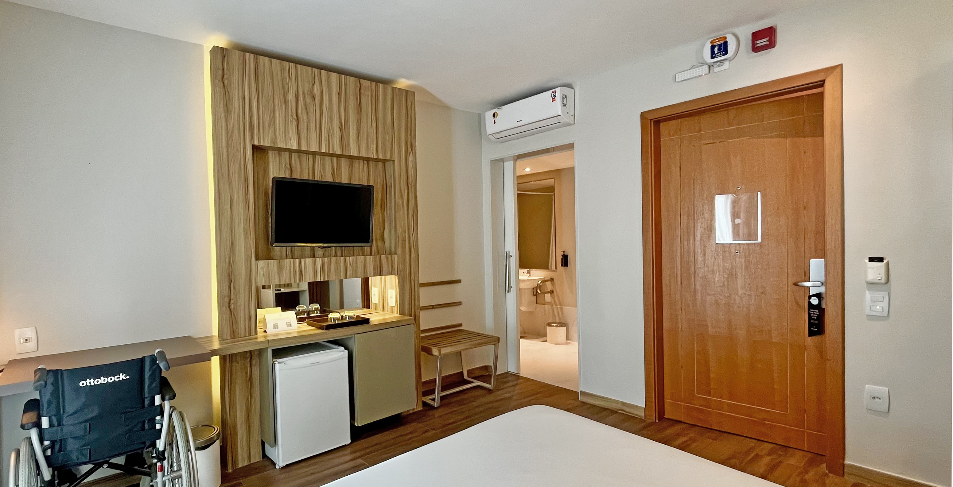 The Adapted Room of Pestana Rio Atlântica has air conditioning, a bed, a desk, and an adapted bathroom