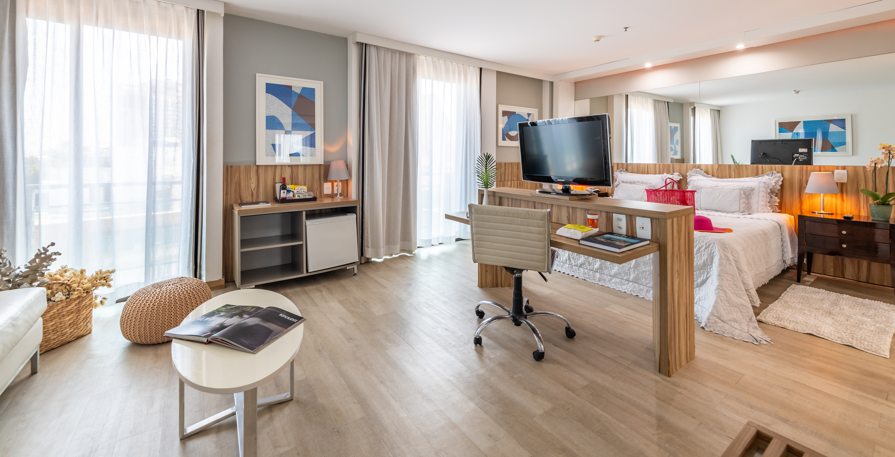 The Junior Suite of Pestana Rio Atlântica has a double bed, desk, television, and two windows with curtains