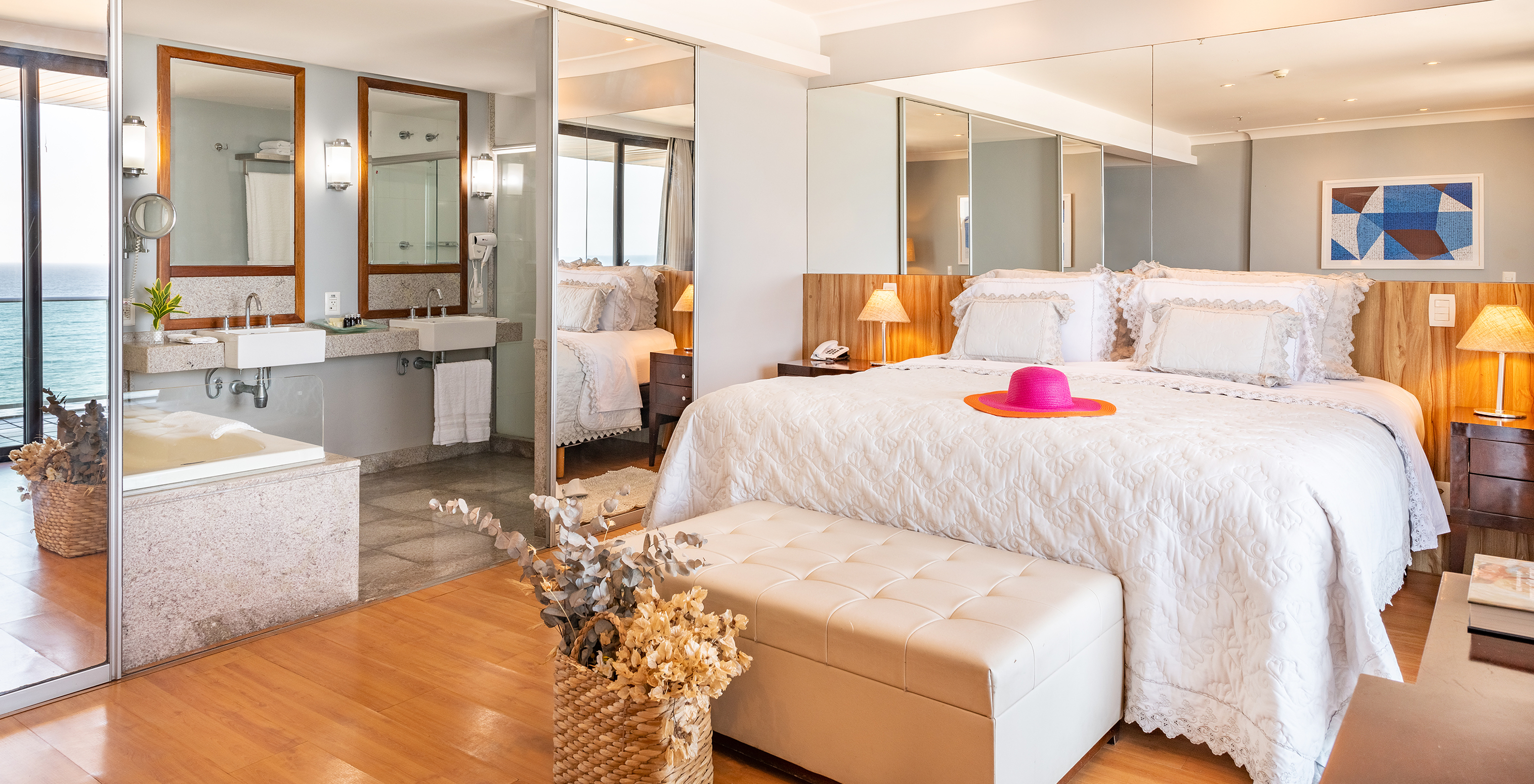 The Ocean Suite of Pestana Rio Atlântica has a double bed and a bathroom with two sinks and two mirrors