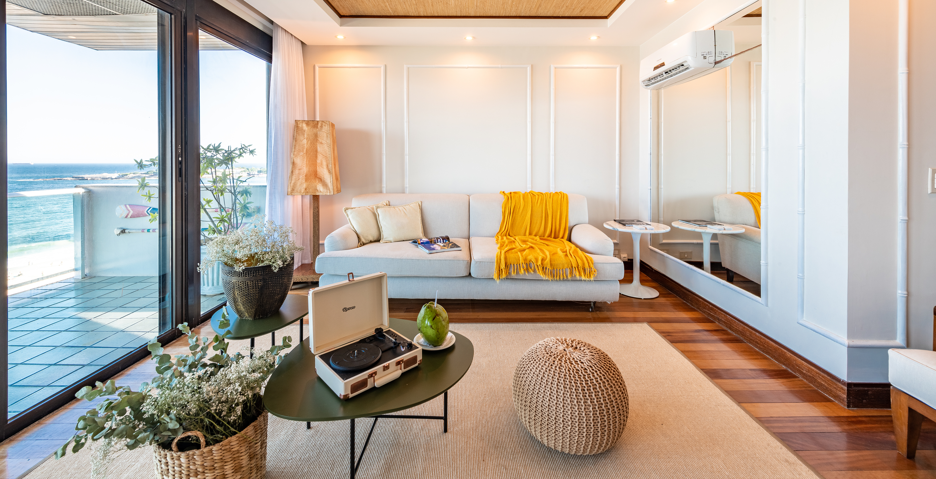 The Presidential Suite of Pestana Rio Atlântica has a living room with wooden ceiling, white sofa, and sea view