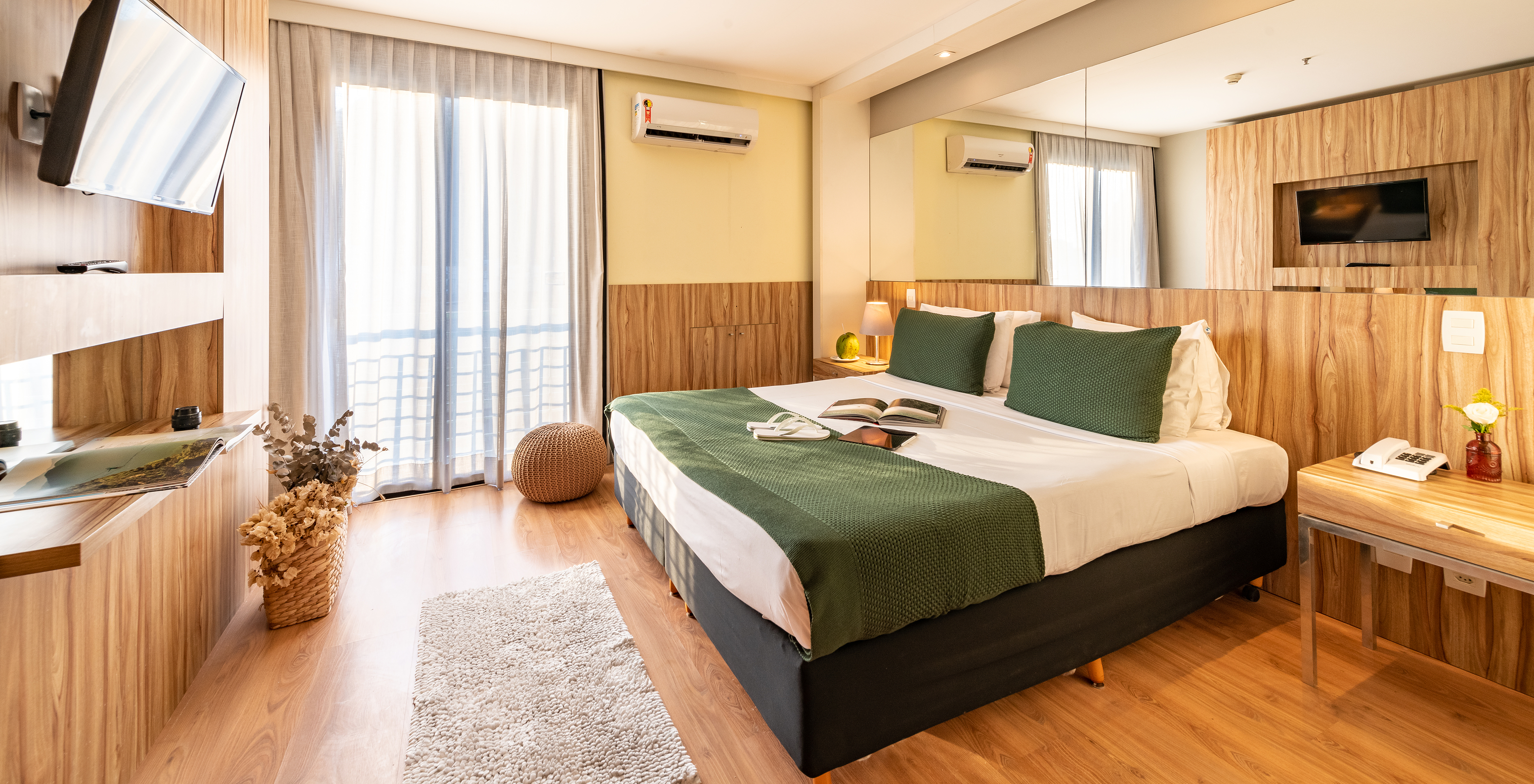 The Lateral Sea View Suite of Pestana Rio Atlântica has a double bed with a mirror on the headboard and a television in front