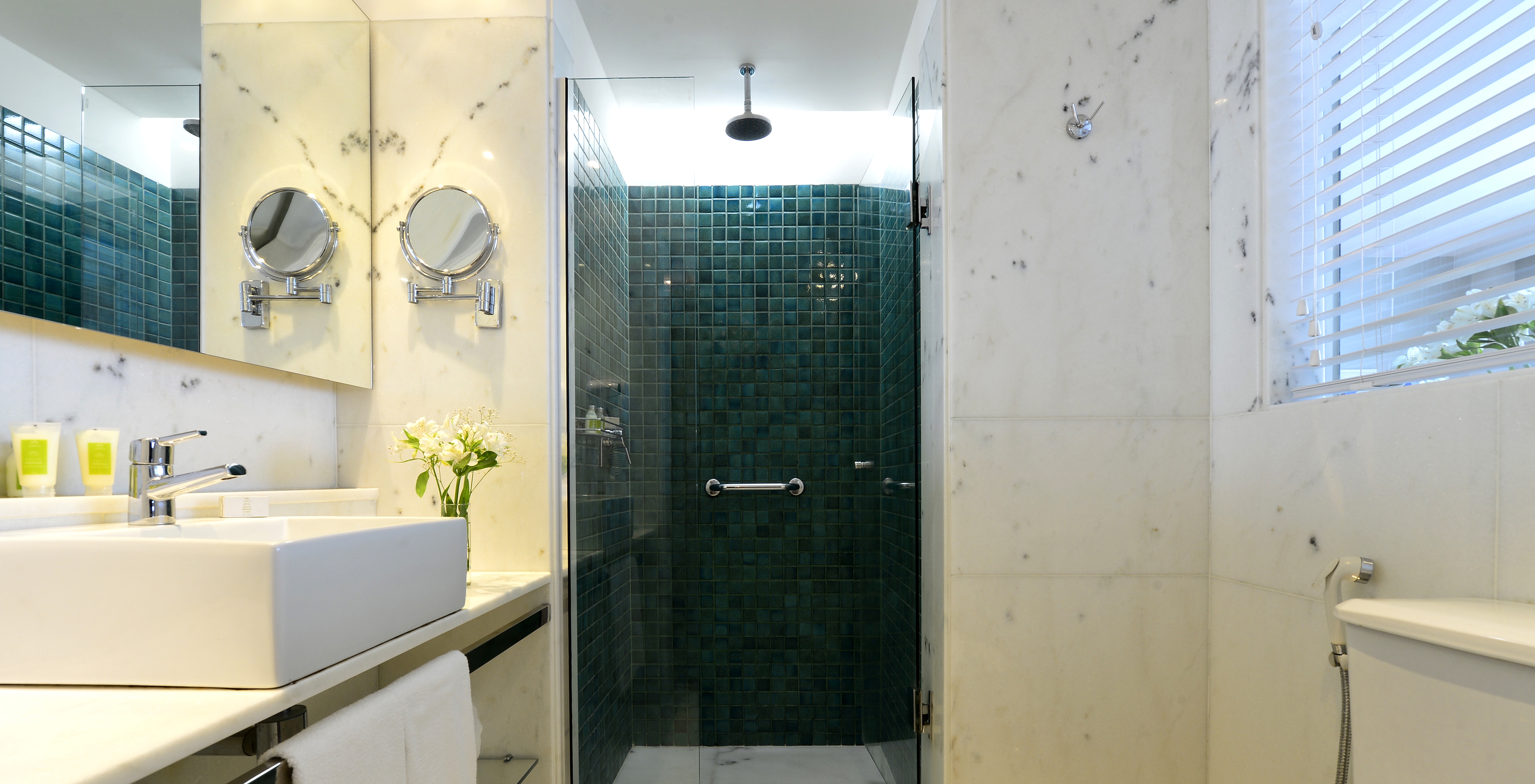 The Lateral Sea View Twin Room of Pestana Rio Atlântica has a bathroom with shower, toilet, sink, and mirror