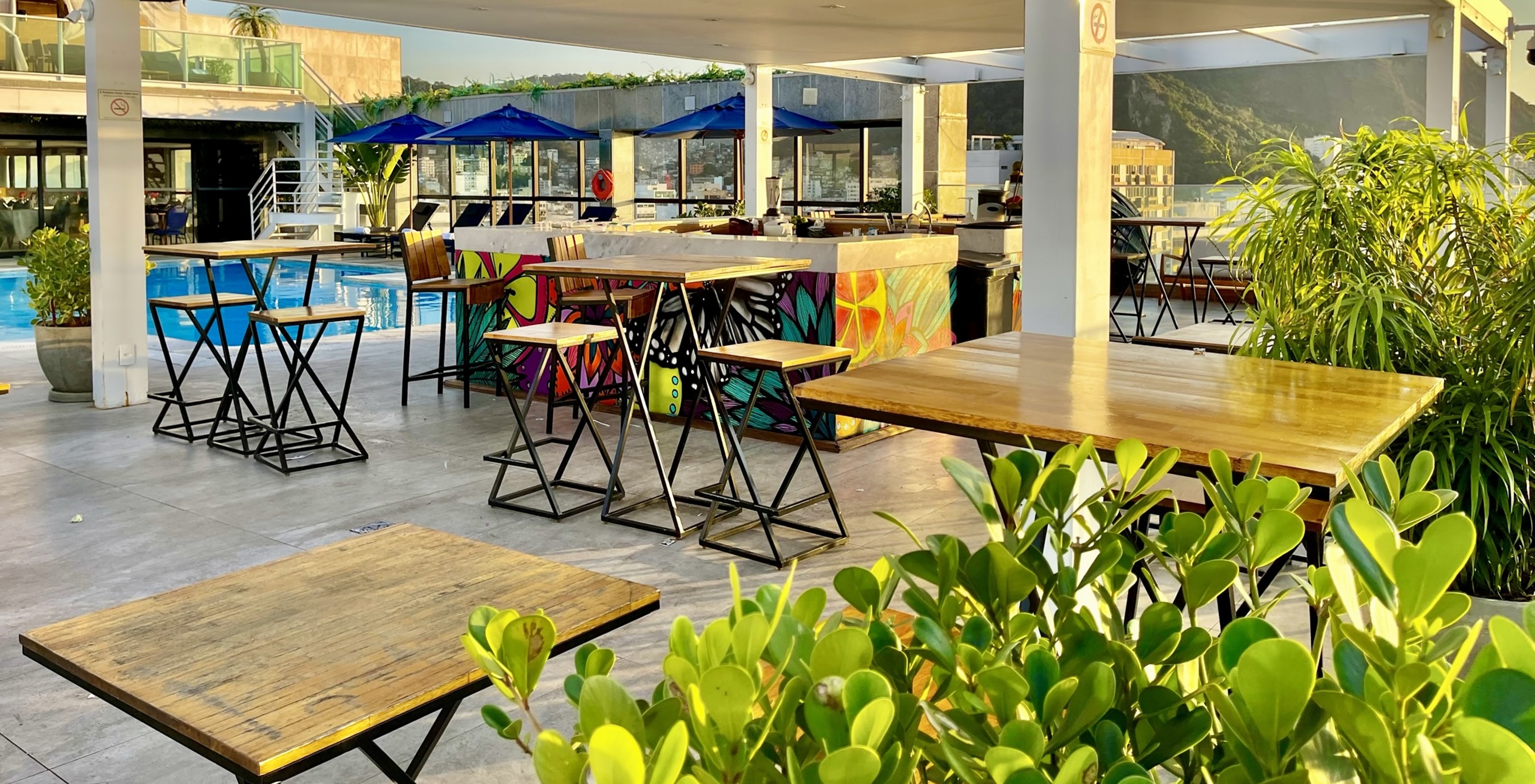 The Deck bar at the 4-Star Hotel in Rio de Janeiro features several tables, loungers, and serves drinks by the pool