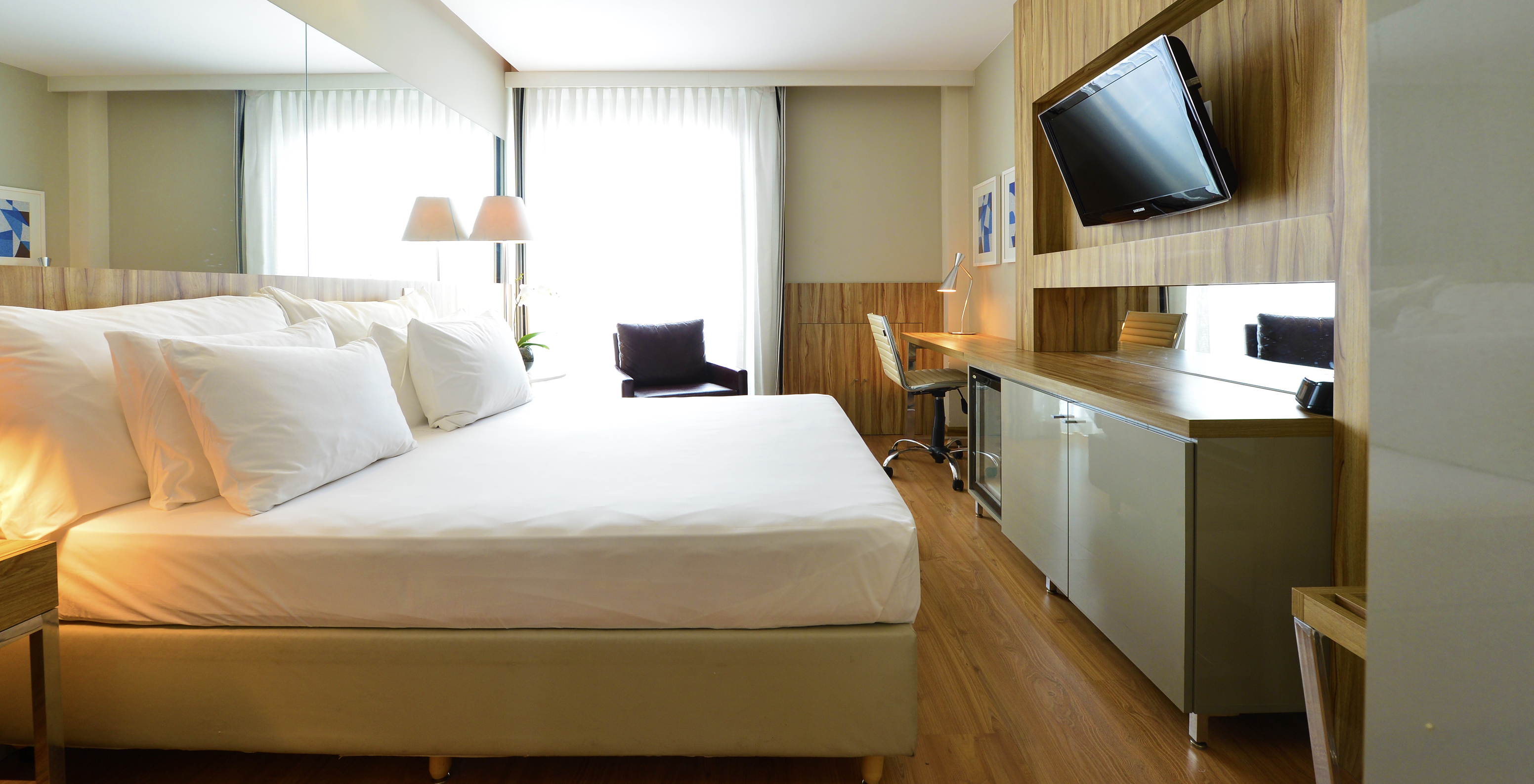 The Standard Double Room of Pestana Rio Atlântica has a double bed, a television, a desk, and an armchair