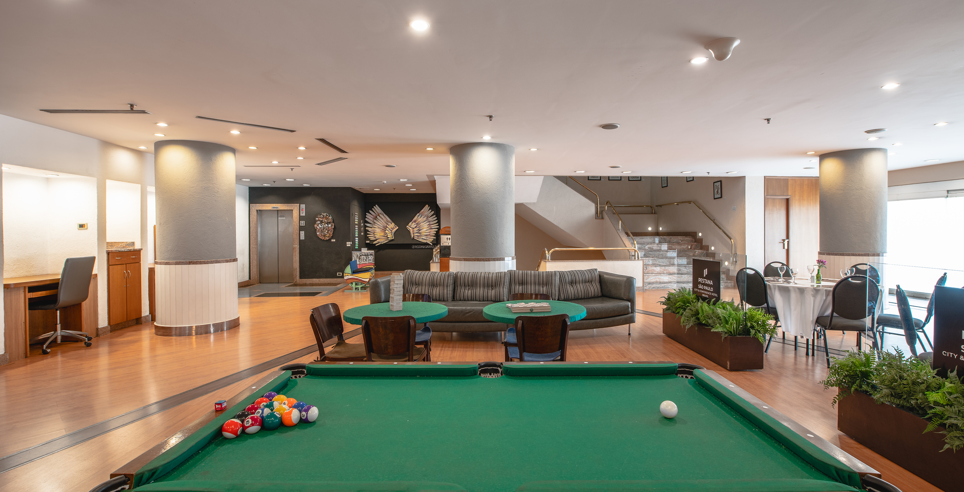 Lobby of a 4-star hotel in São Paulo, a spacious area with natural light, tables, sofas, and a pool table