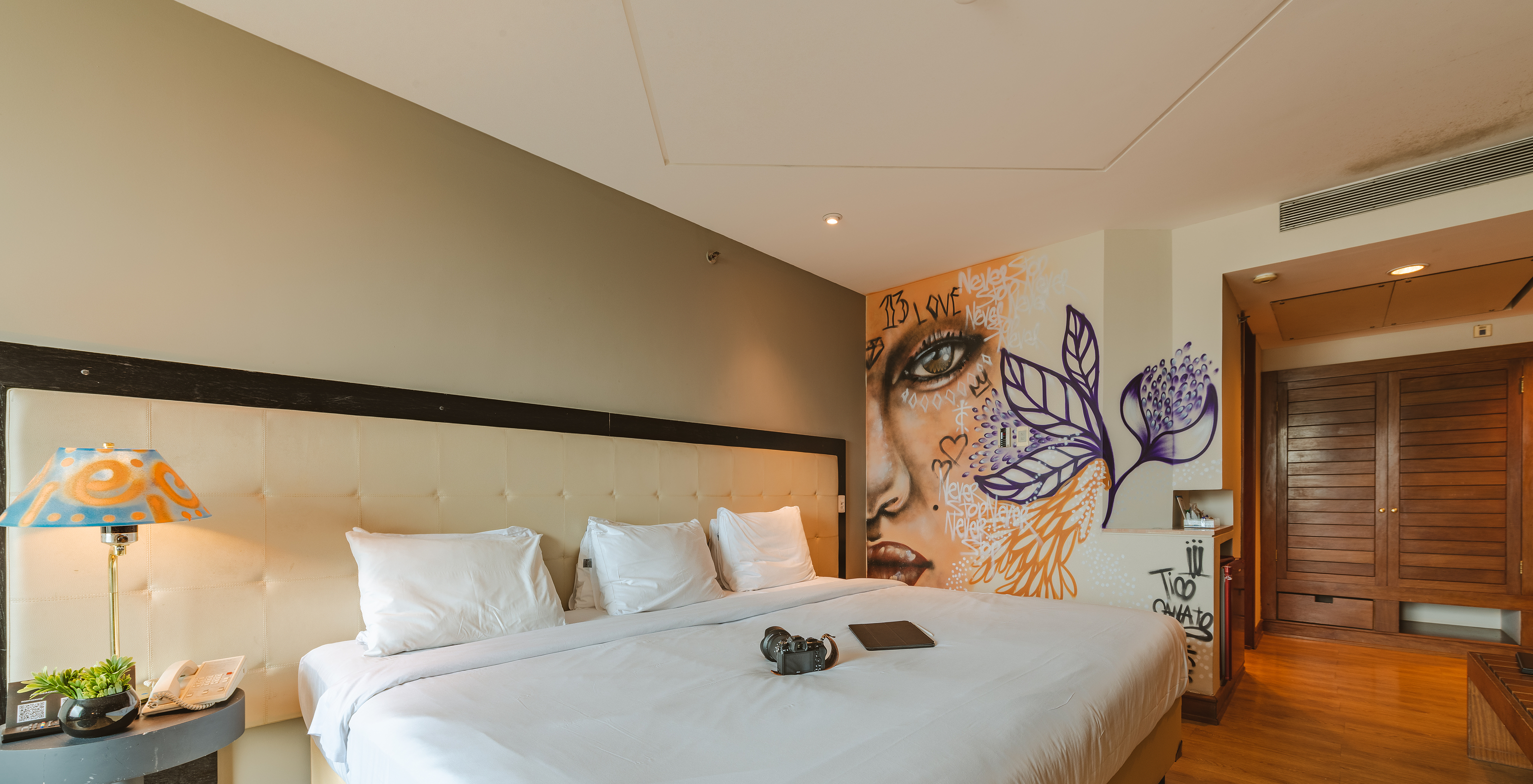 The Art Room of Pestana São Paulo has a triple bed and wall paintings and lamps by artist Tico Canato