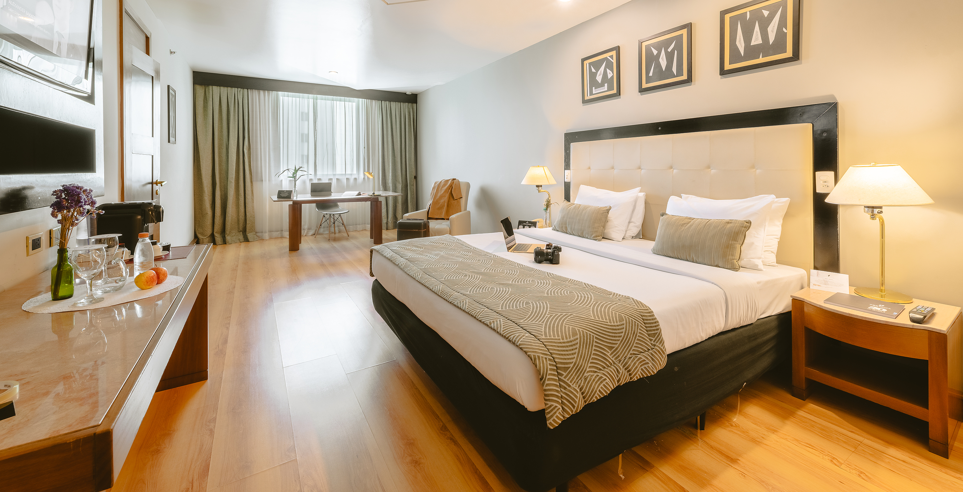 The Executive Suite of Pestana São Paulo has a room with a double bed, television, armchair, and a desk