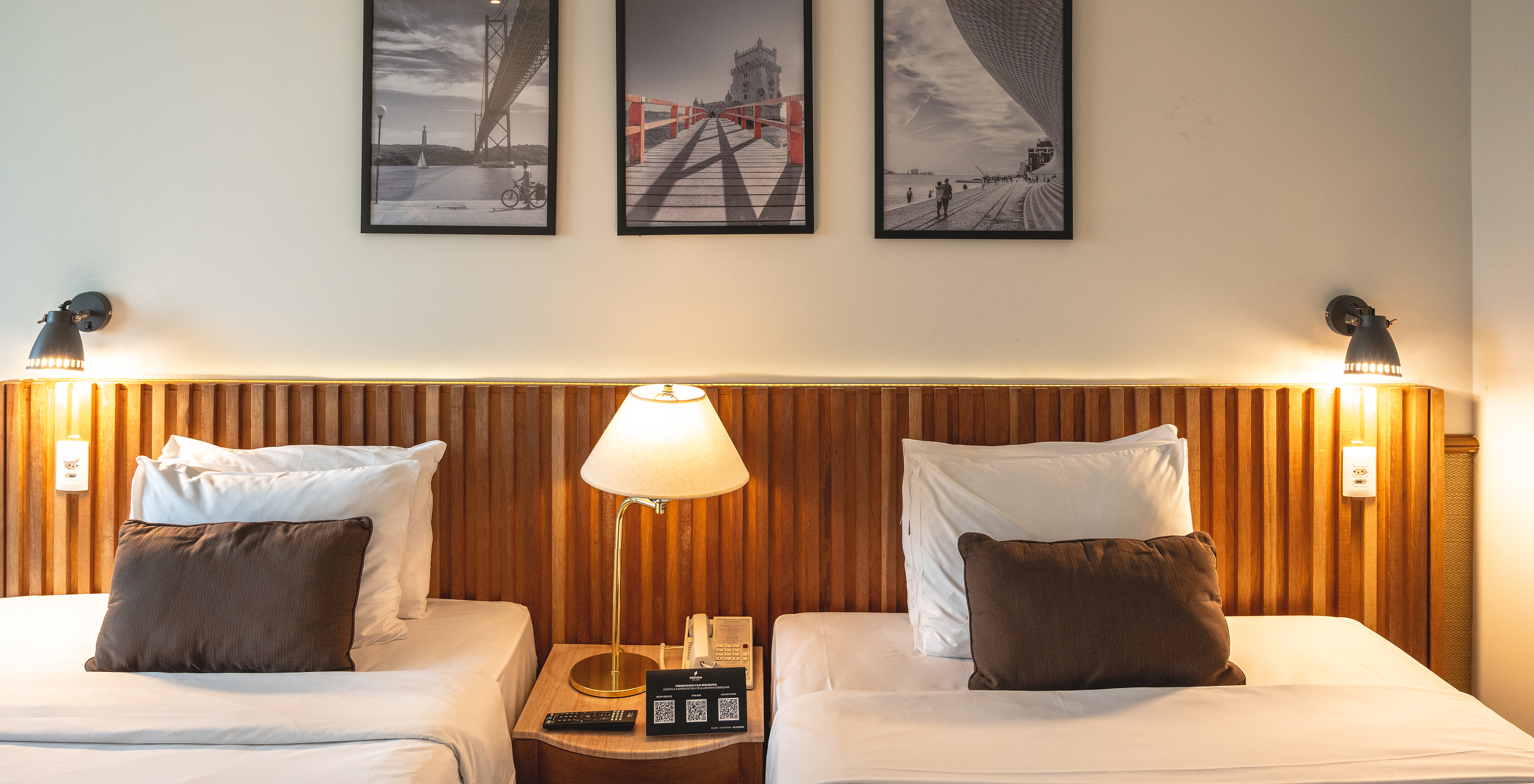 The Deluxe of Pestana São Paulo has two single beds, a wooden headboard, and a table in the center