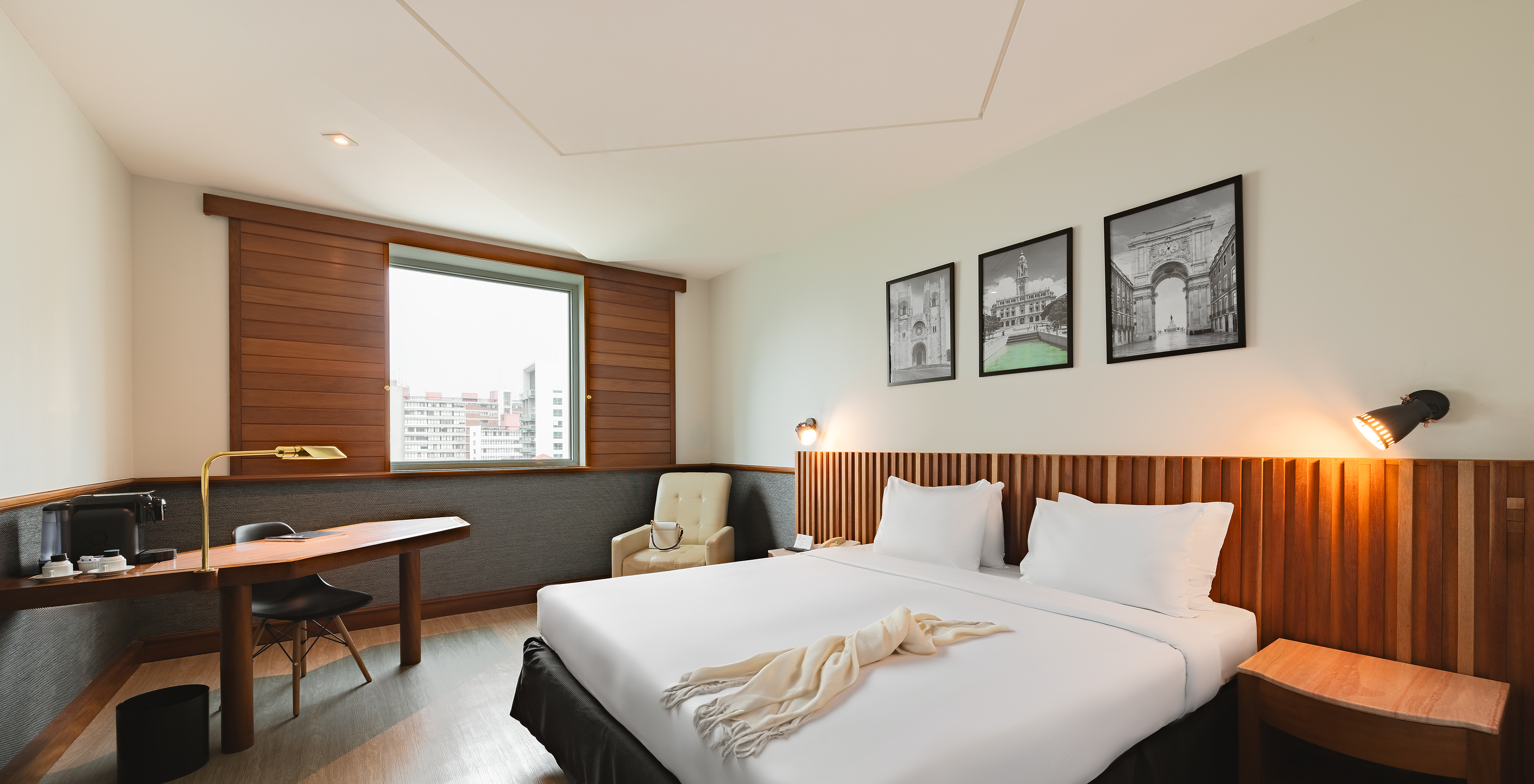 The Deluxe of Pestana São Paulo has a double bed and a window with a view of downtown São Paulo