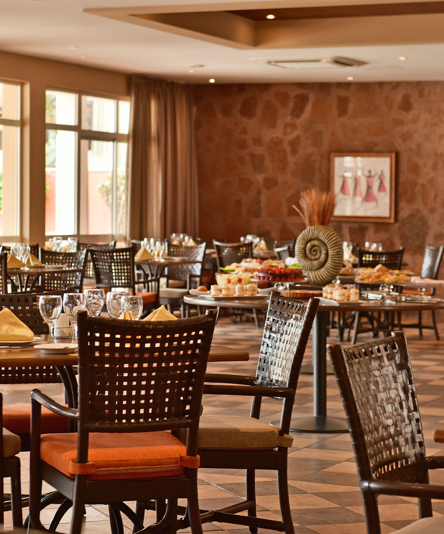 Pestana Tropico has a large restaurant with various chairs and a wide variety of food