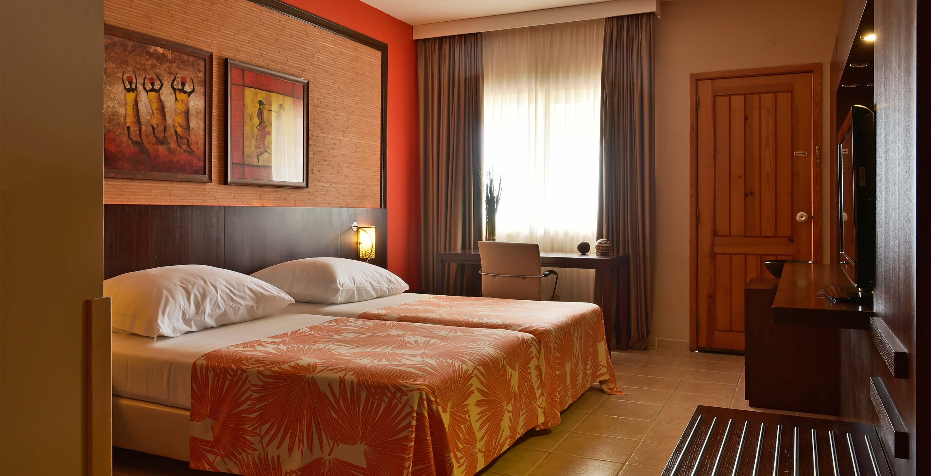 The Premium room at Pestana Tropico features two single beds, television, and desk with chair