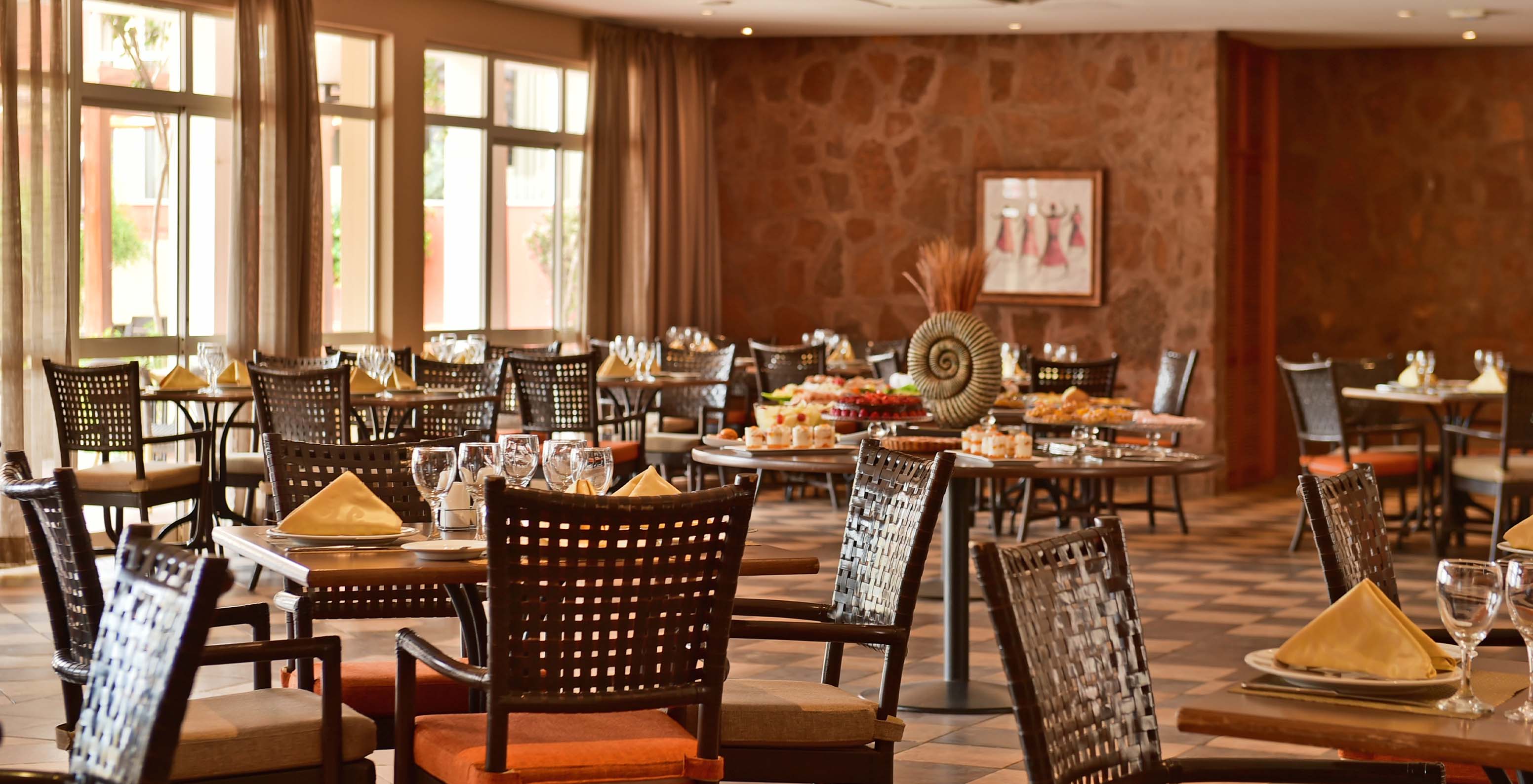 The Pestana Tropico has a spacious restaurant with various chairs and a wide variety of food