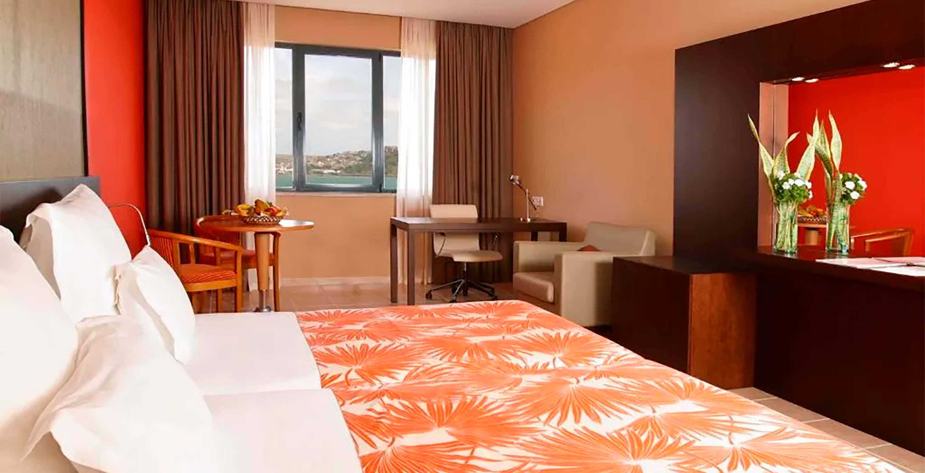 The Premium Suite at Pestana Tropico features two single beds, desk with chair, a table, and sea view