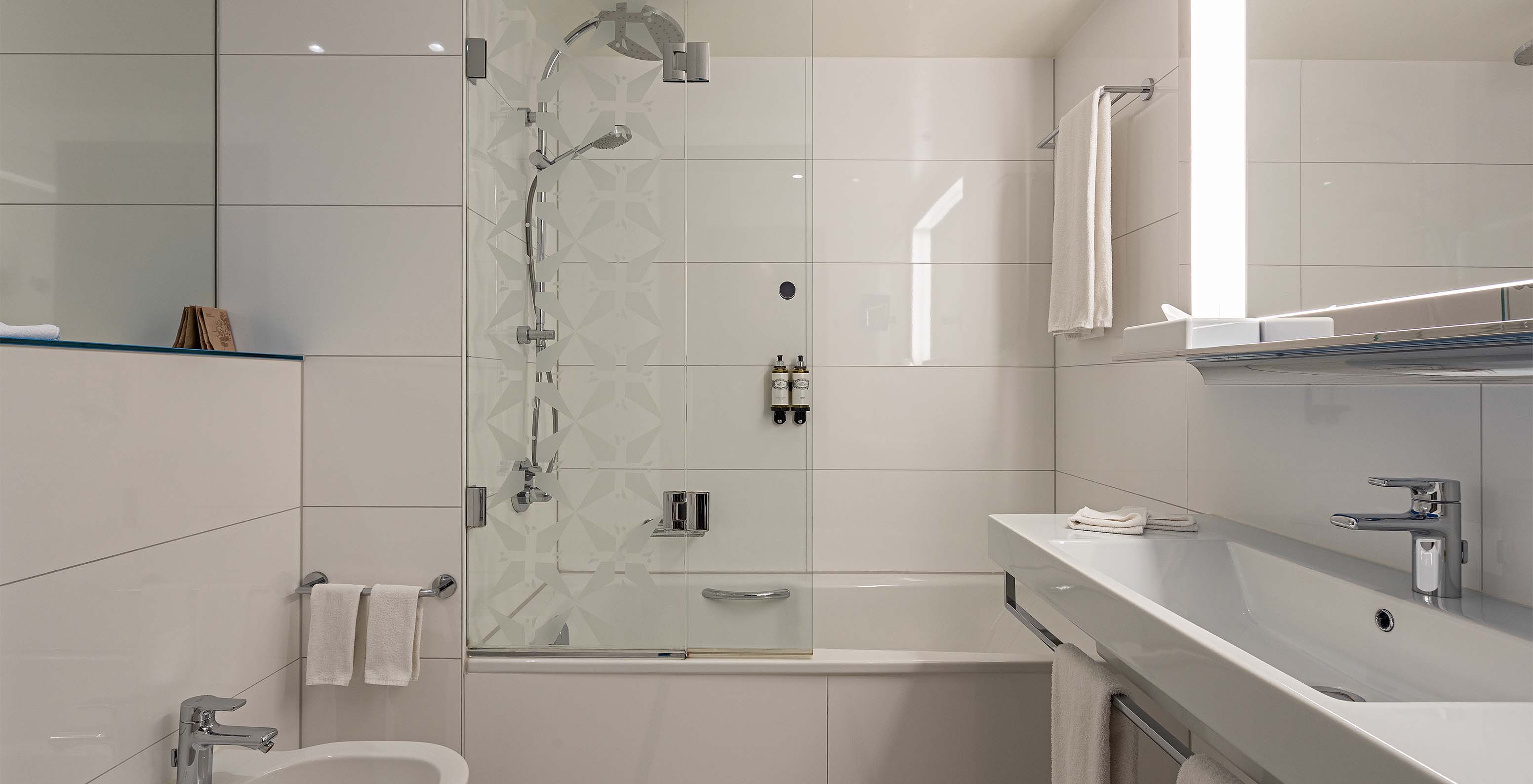 Grand Deluxe room at Pestana Berlin Tiergarten has a bathroom with bathtub and shower, and a sink