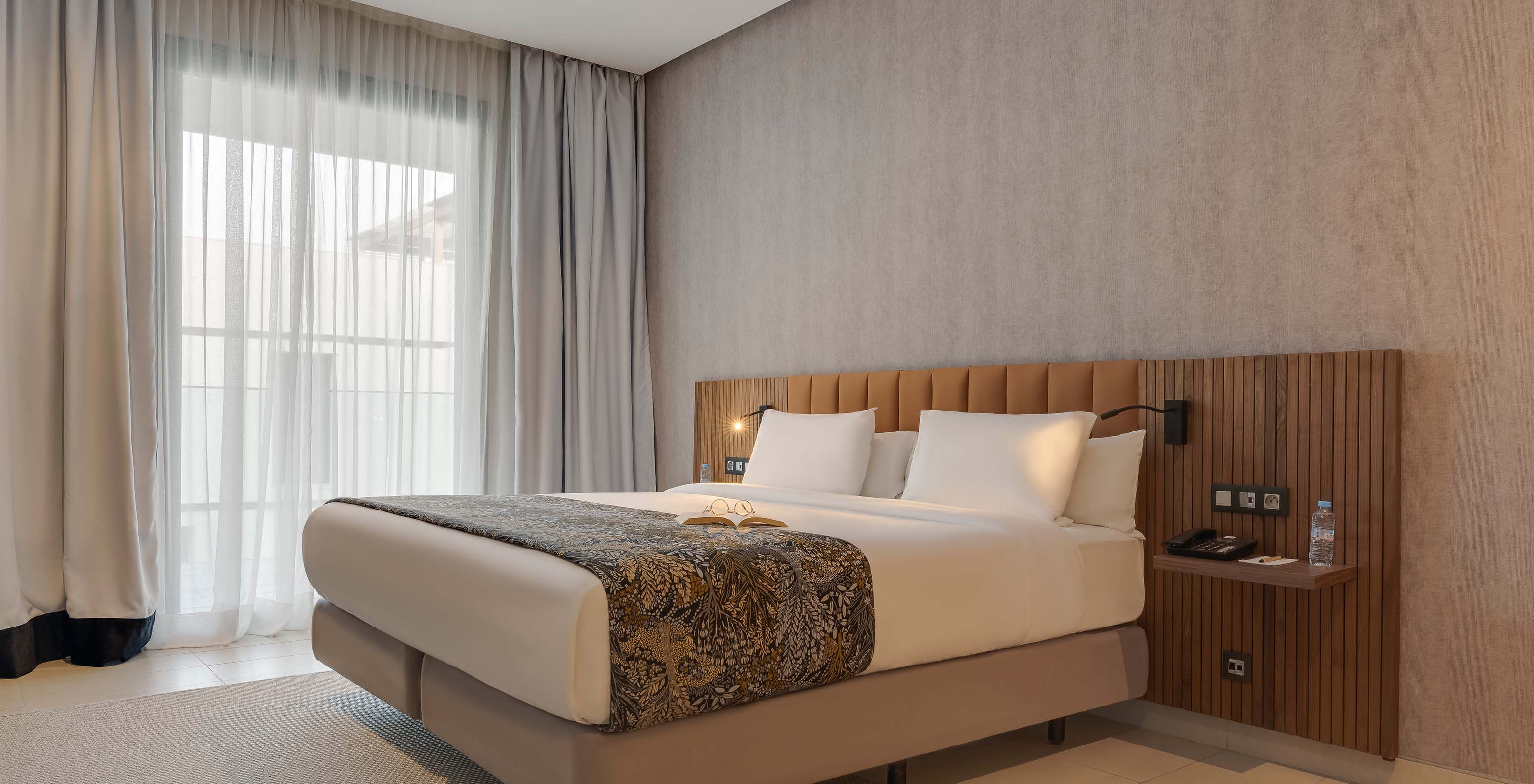 The Family Premium Superior Suite at Pestana Casablanca has a bedroom with a double bed and modern decor