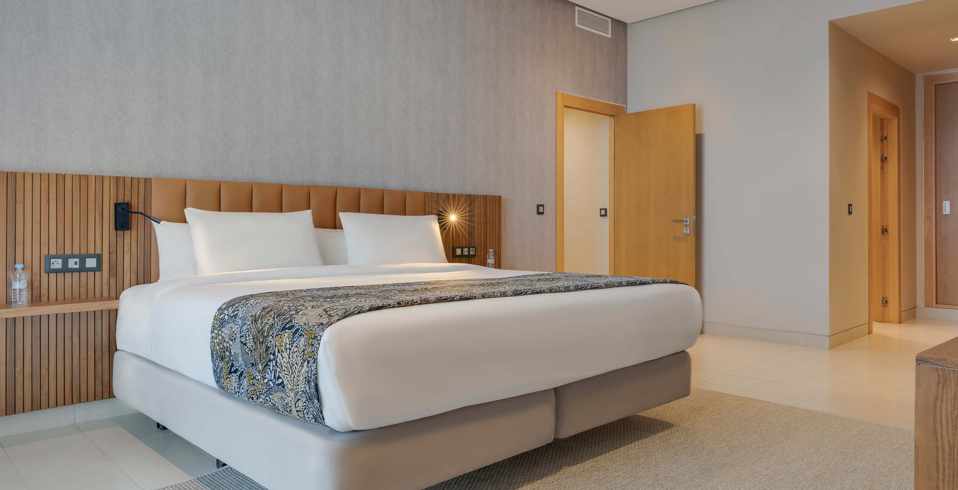 The Family Suite at Pestana Casablanca has a spacious bedroom with a double bed and modern decor