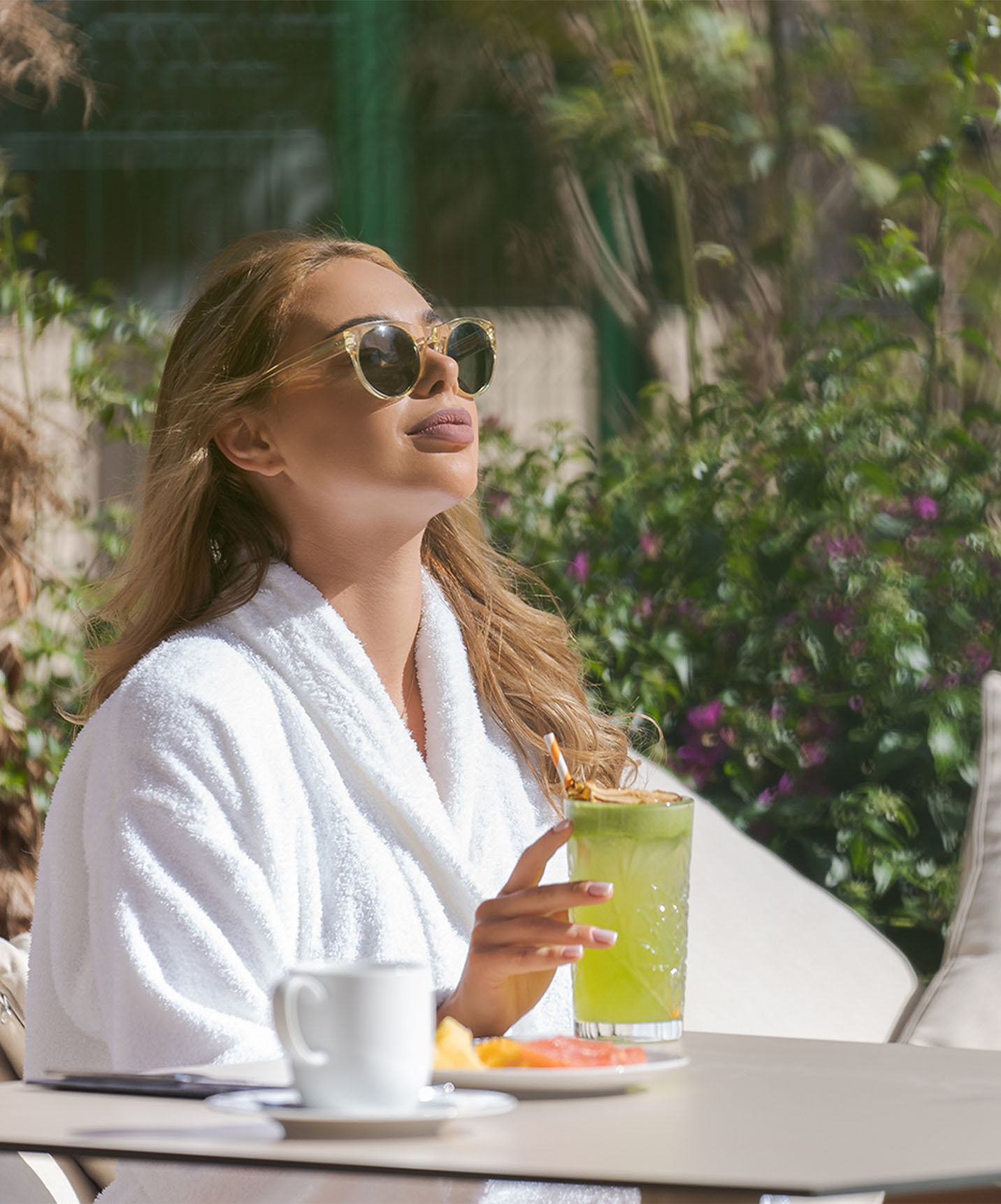 Girl having a meal, a natural juice, coffee, and a plate of fruit at a Lifestyle Hotel in Morocco with pool