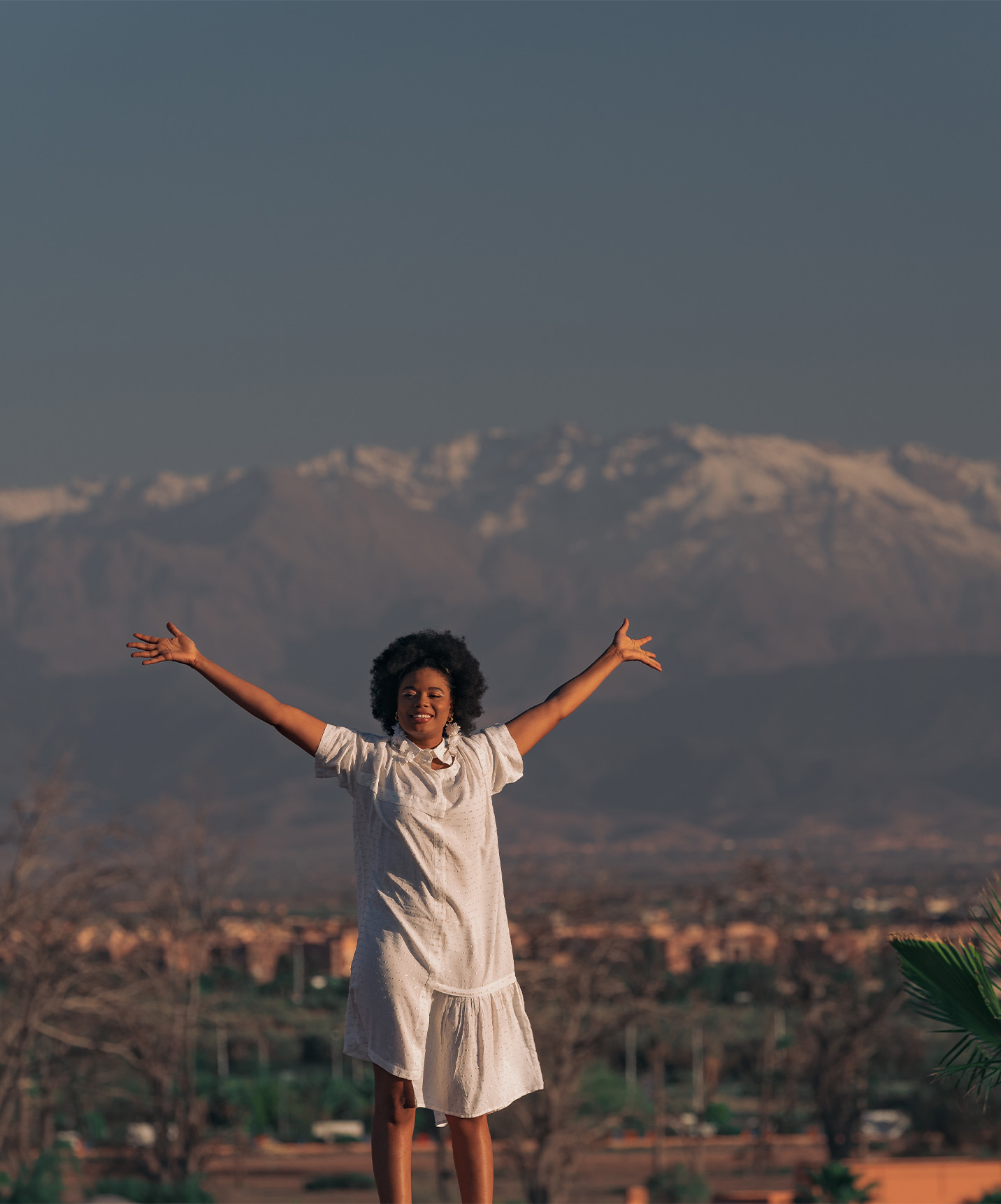 The terrace of the Hotel in Morocco shows a view of the city of Marrakech with the Atlas Mountains in the background