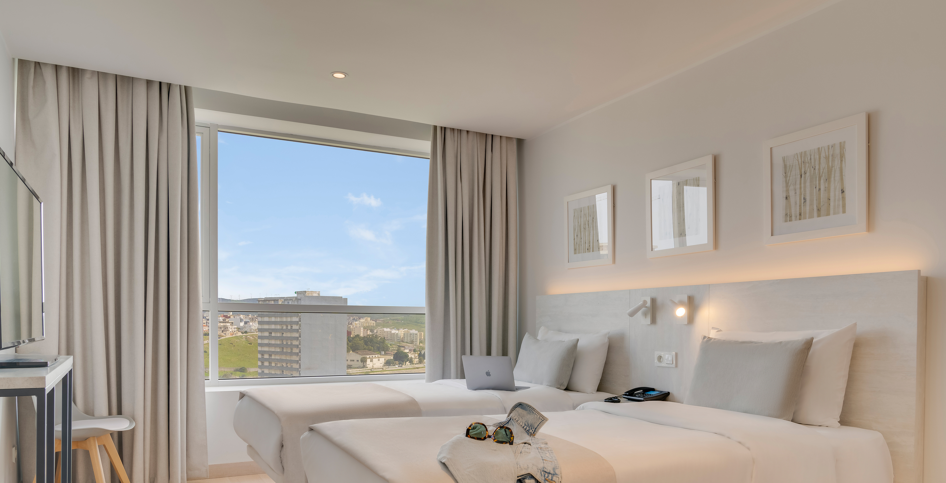 The Family Premium Suite of Pestana Tanger City Center features two separate beds with stone headboards and a window