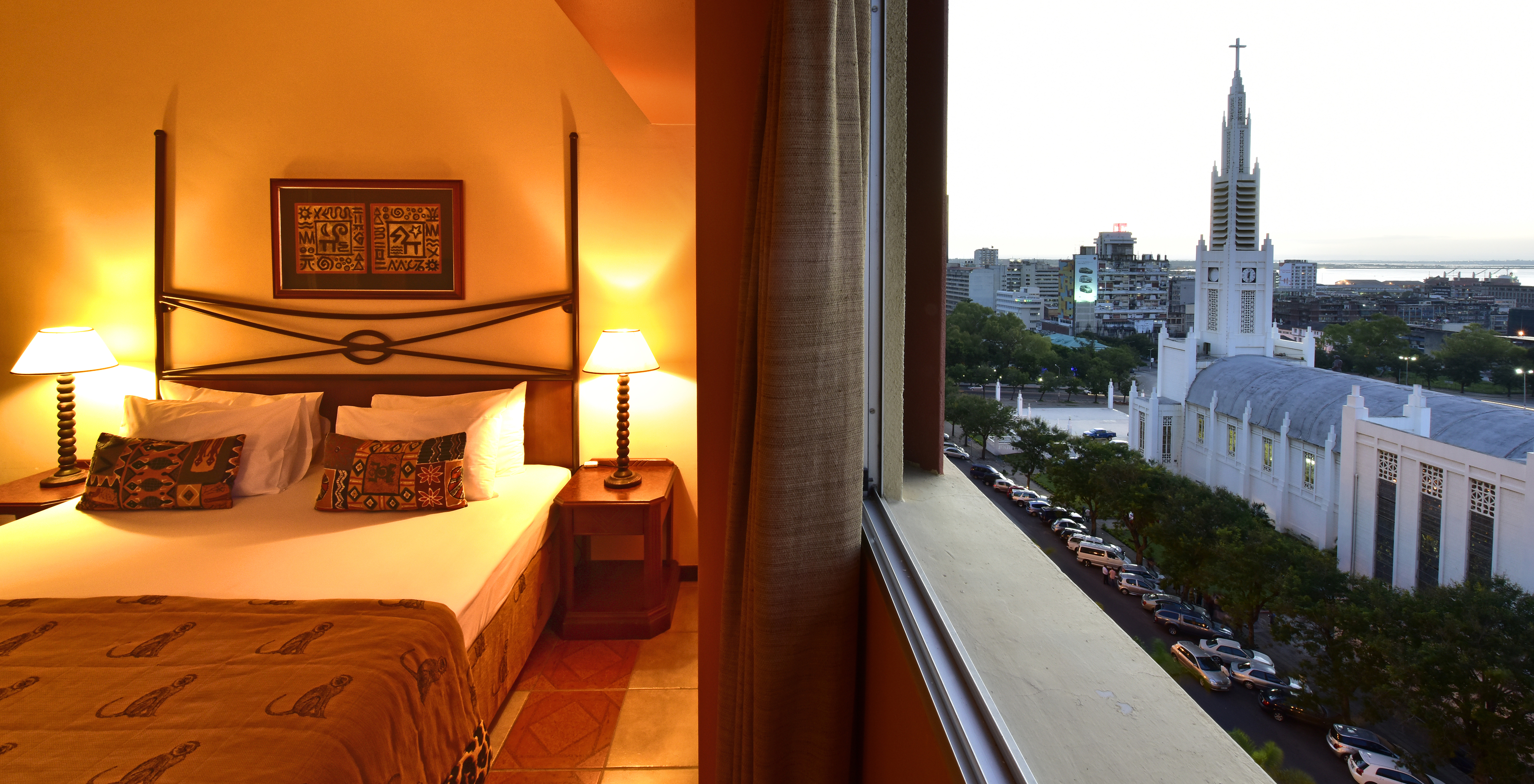 The Executive Suite of Pestana Rovuma has a window next to the bed with a view of Maputo city, including the Cathedral