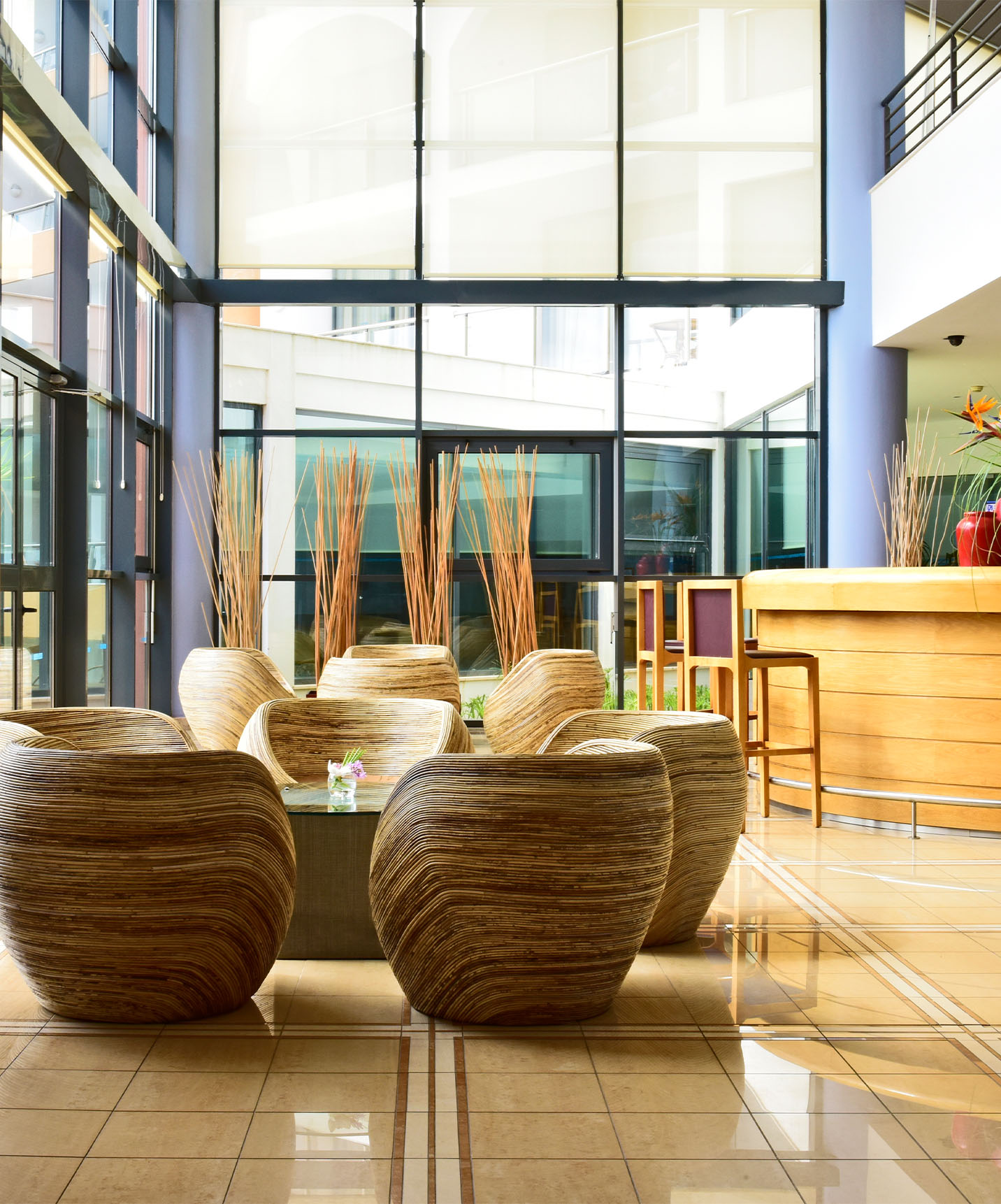 Restaurant with round chairs and central tables, bar counter with glass windows