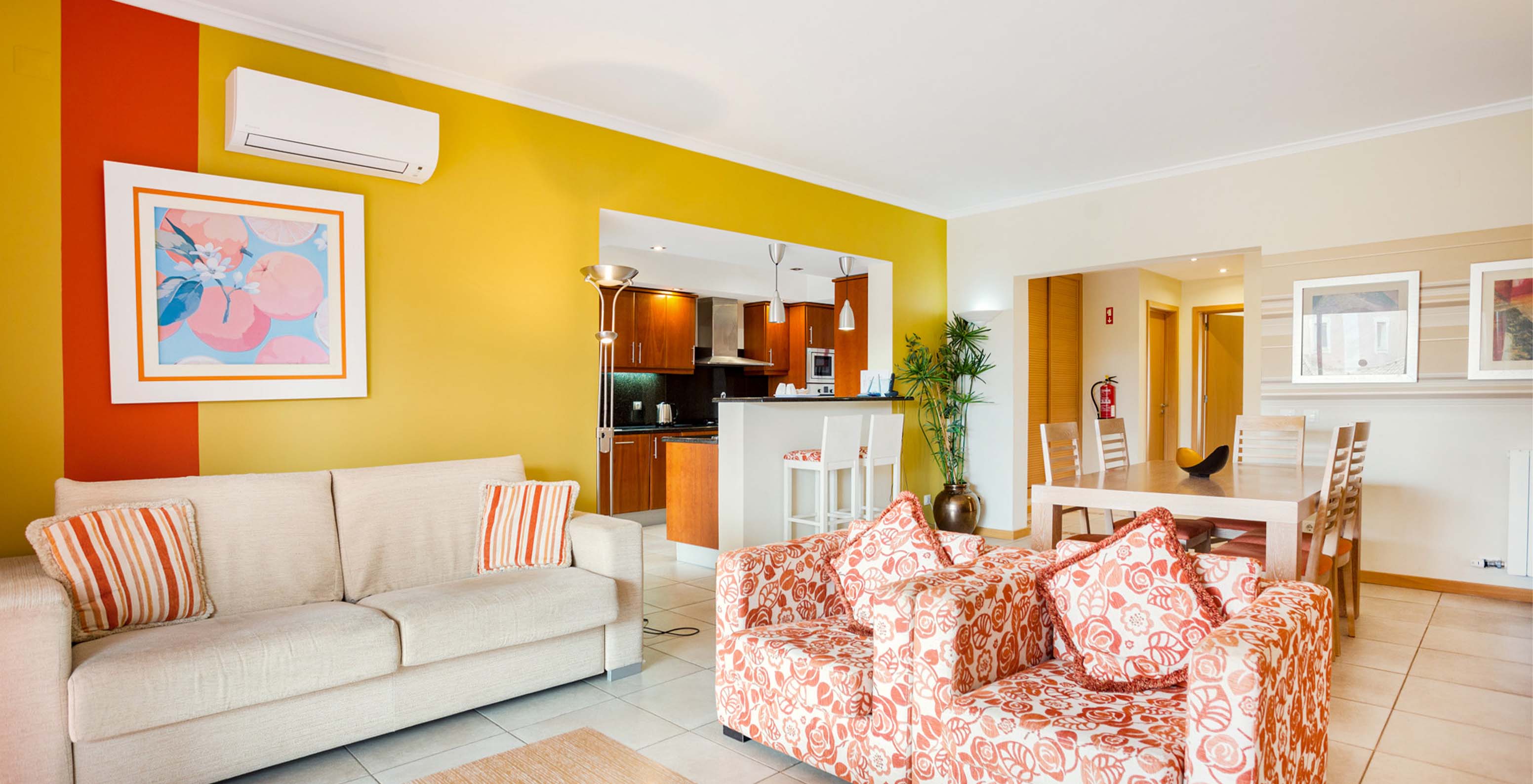 The T1 Apartment at Pestana Carvoeiro Golf has a living room with sofas, open space kitchen, and dining table