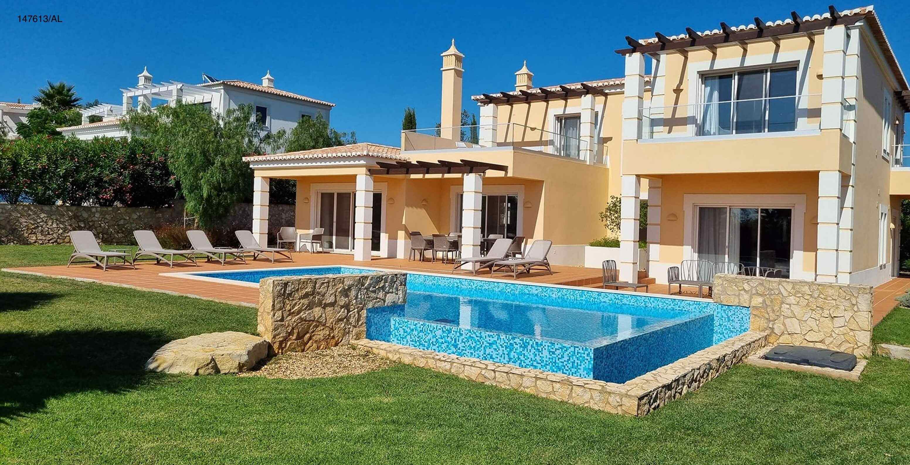 The Pestana Carvoeiro Golf V5 Standard Villa has an exterior patio with a pool, grass, and loungers