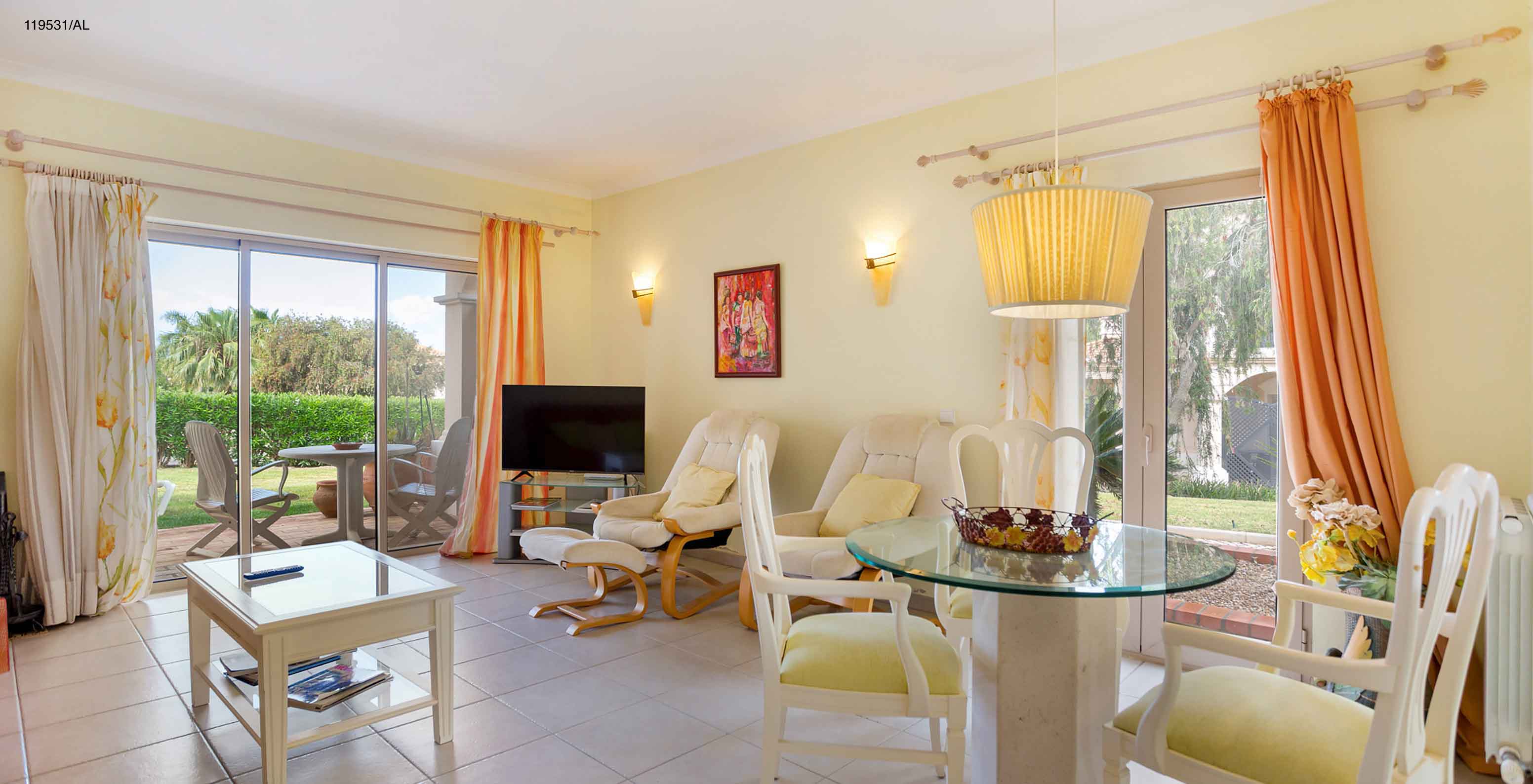 The Pestana Carvoeiro Golf T1 Standard Apartment has a living room with TV, tables, chairs, and an outdoor view