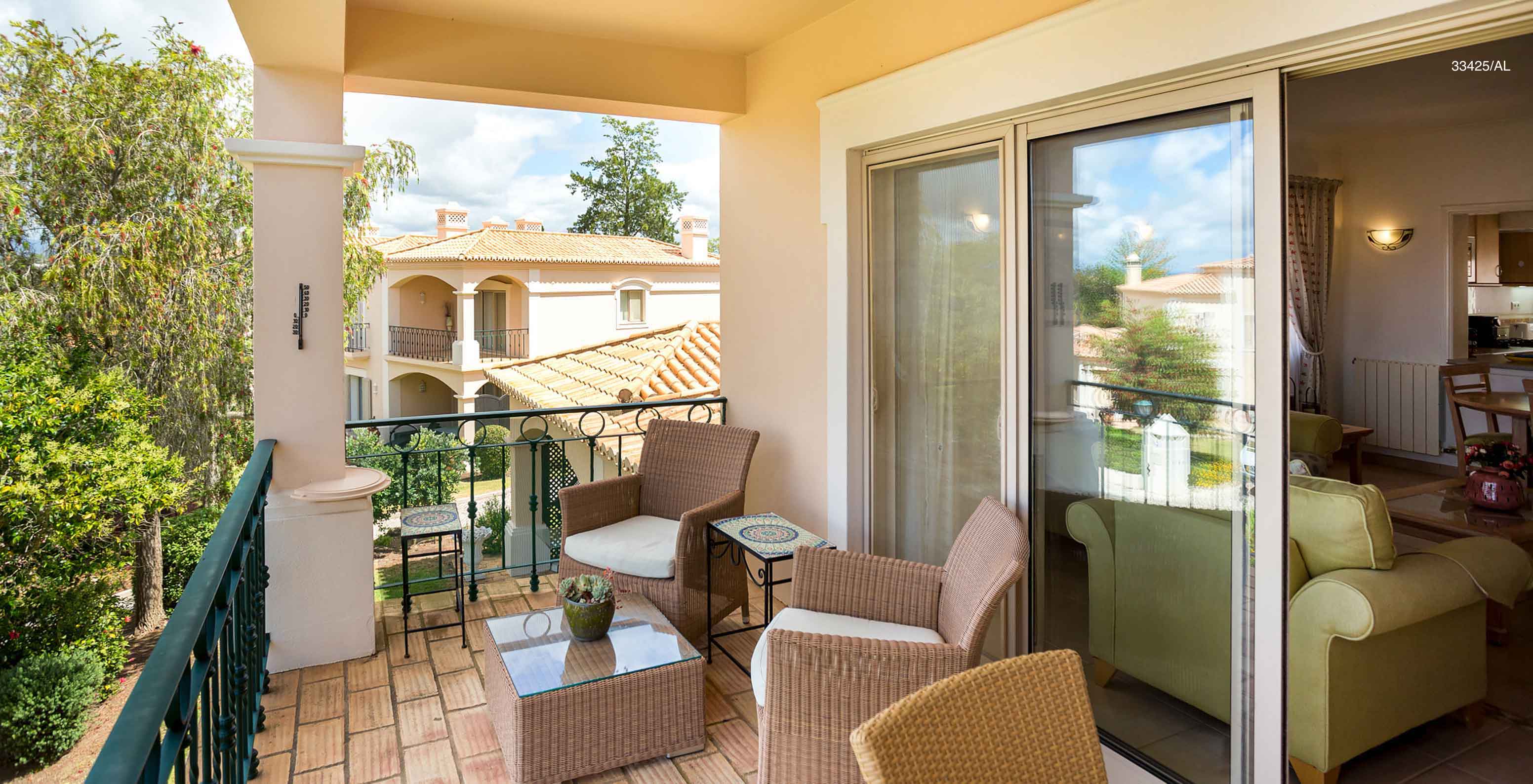 The Pestana Carvoeiro Golf T2 Standard Apartment has a balcony with a table, two chairs, and garden views