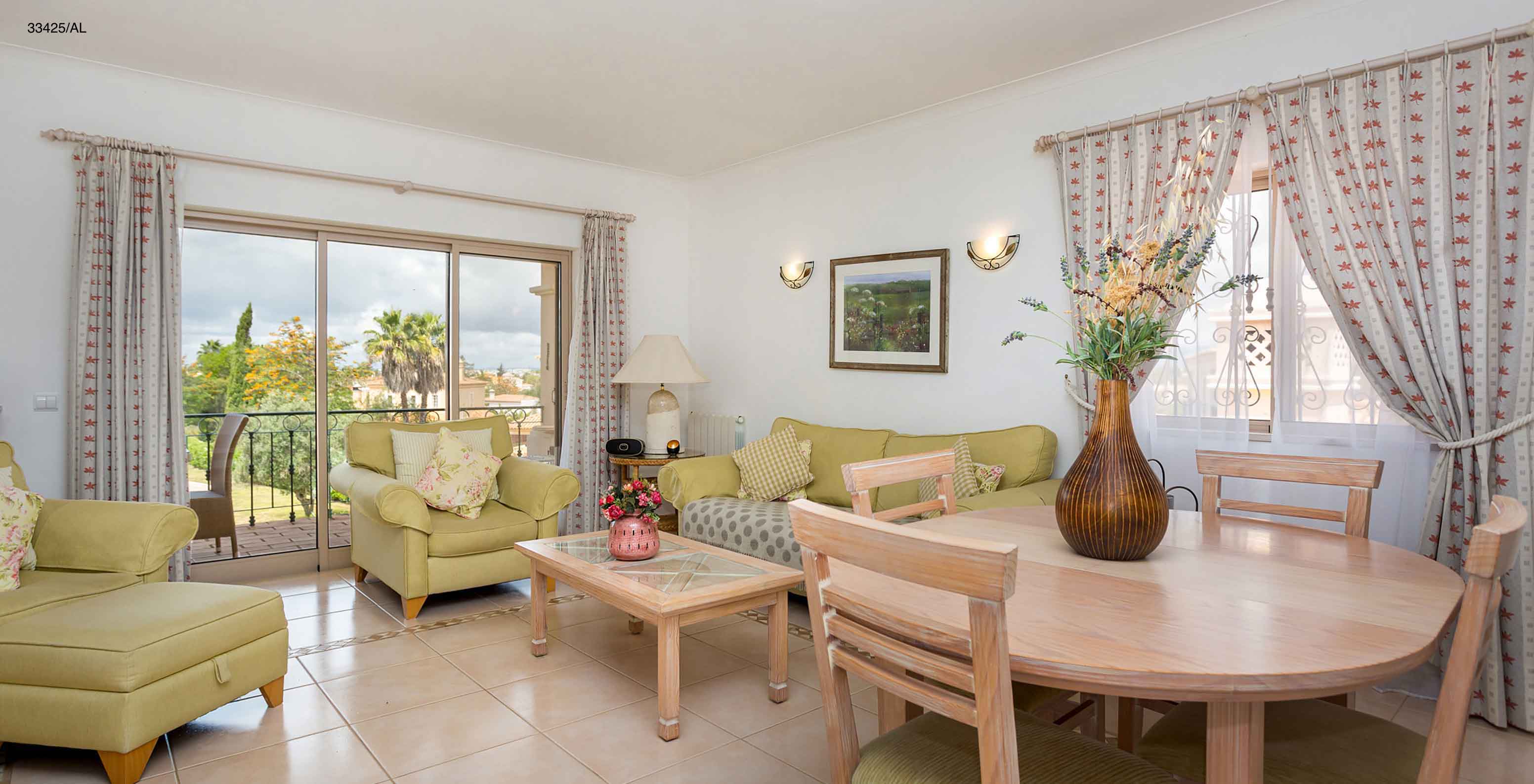 The Pestana Carvoeiro Golf T2 Standard Apartment has a living room with green sofas and a round table