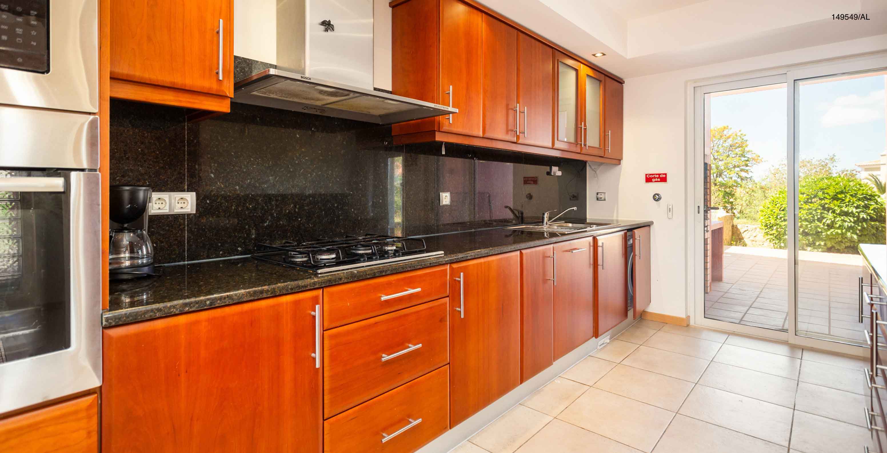 The Pestana Carvoeiro Golf T2 Superior Apartment has a kitchen with wooden cabinets and appliances