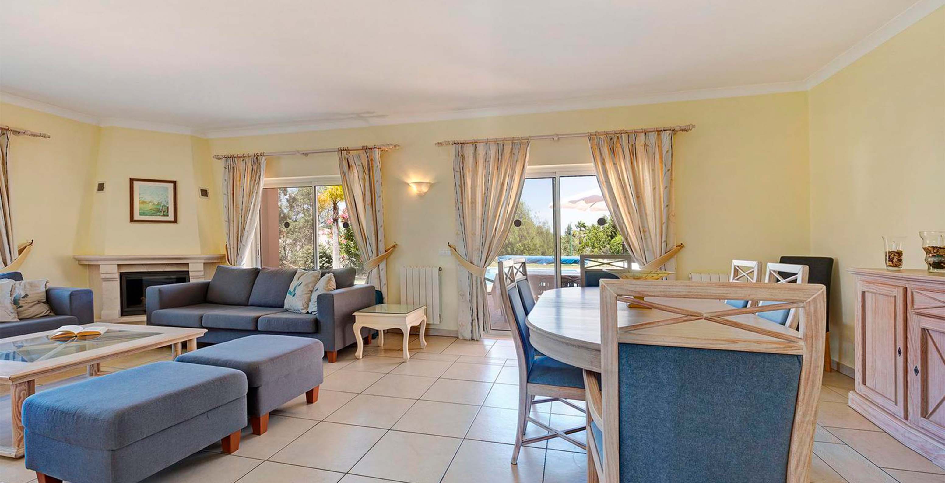 The V4 Villa at Pestana Carvoeiro Golf has a spacious living room with sofas, a dining table, and windows