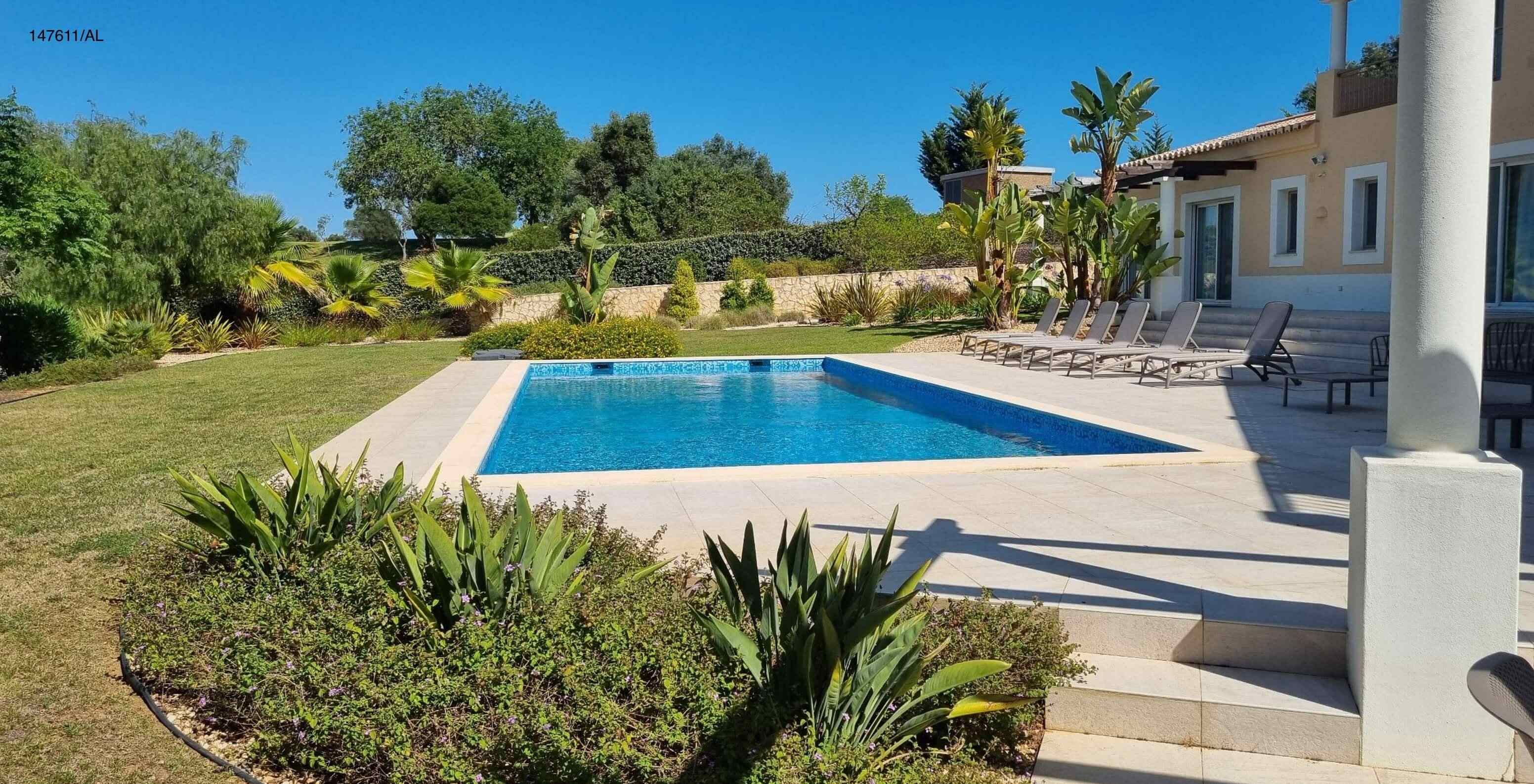 The Pestana Carvoeiro Golf V5 Standard Villa has an exterior patio with a pool, grass, and loungers