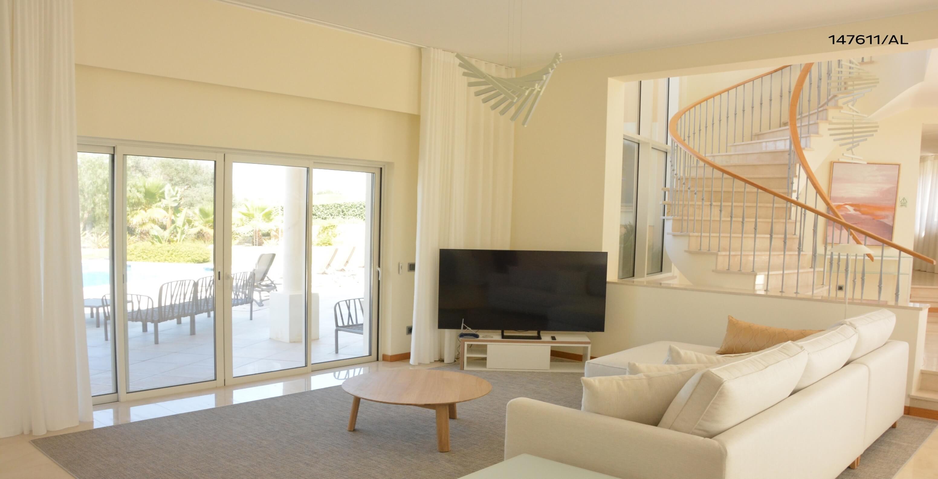 The Pestana Carvoeiro Golf V5 Standard Villa has a living room with a beige sofa, a table, and a TV