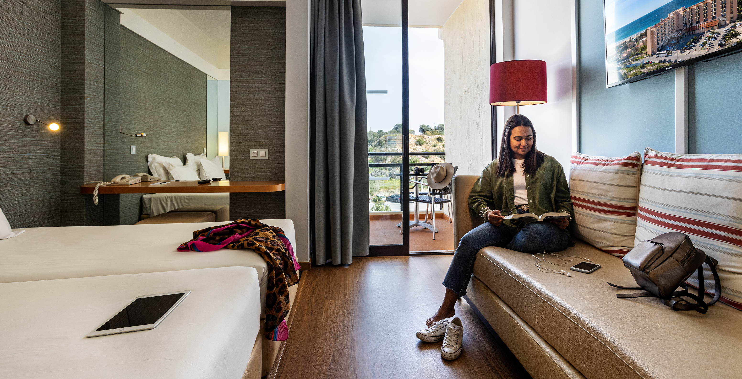 The Deluxe Ground View at Pestana Dom João II includes a sofa, a mirror, and a balcony overlooking the garden