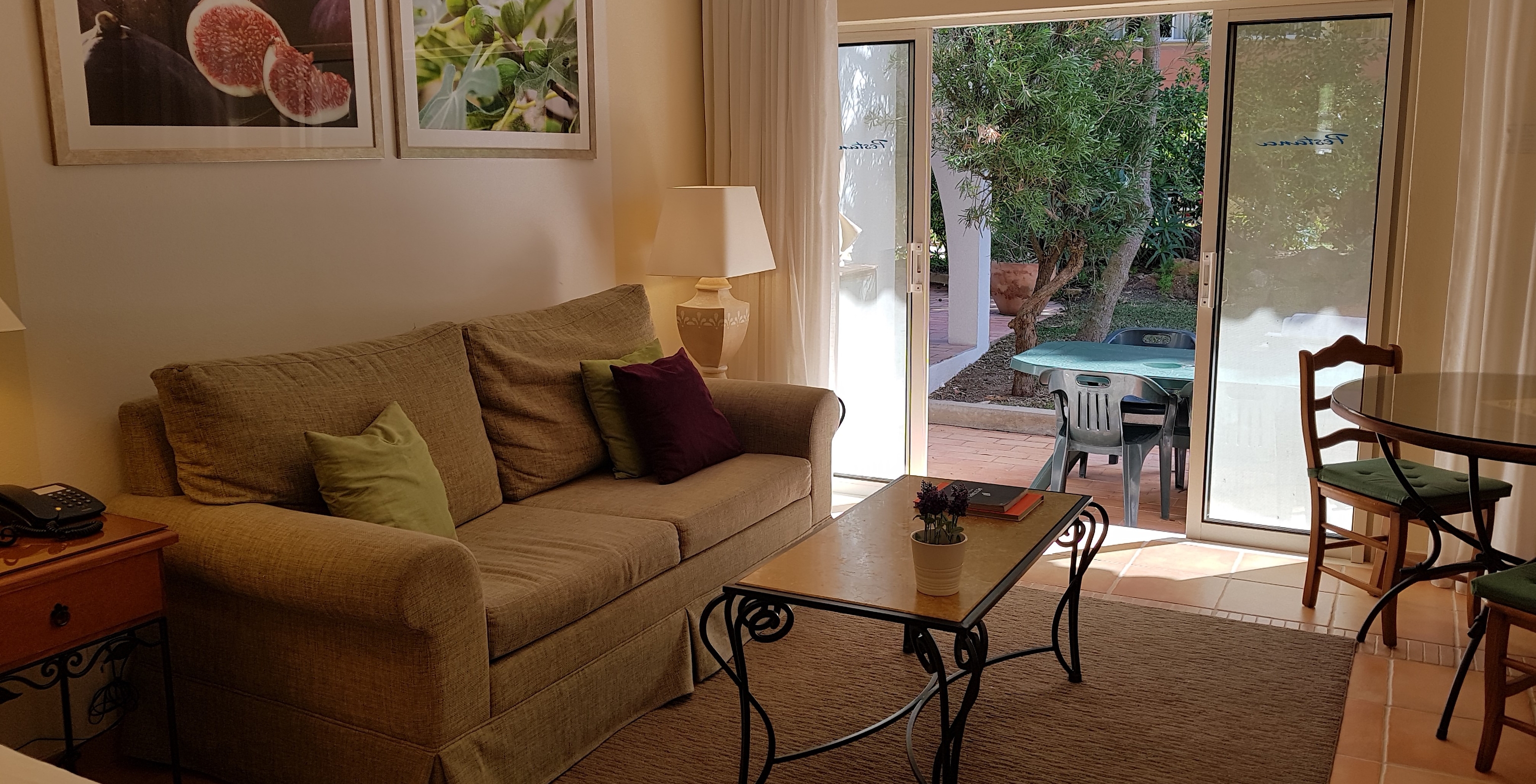 The Studio do Pestana Palm Gardens has a living room with a sofa and a window leading to the garden