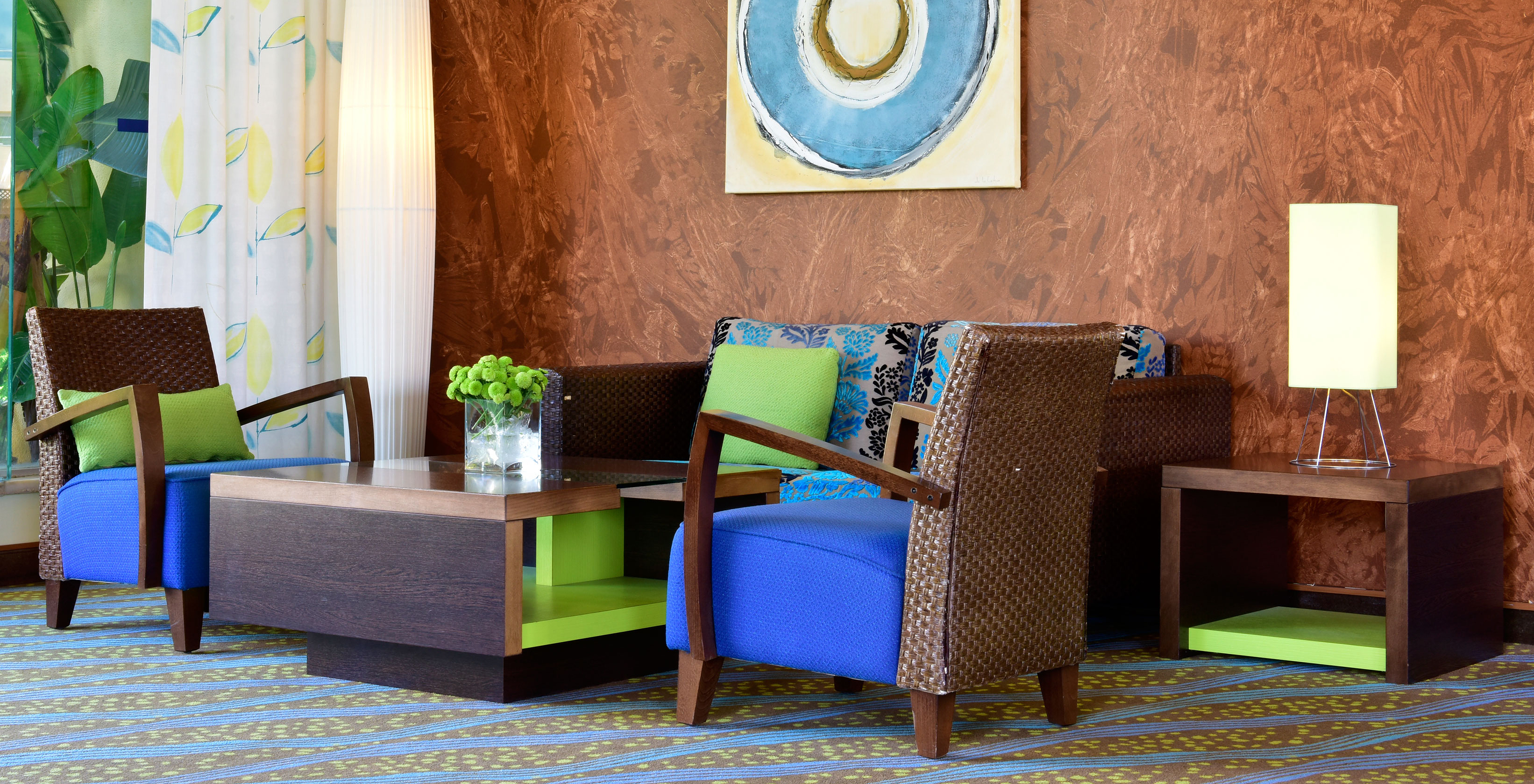 Pestana Viking, has a lobby with two chairs, a sofa, a coffee table, and a painting hanging on the wall