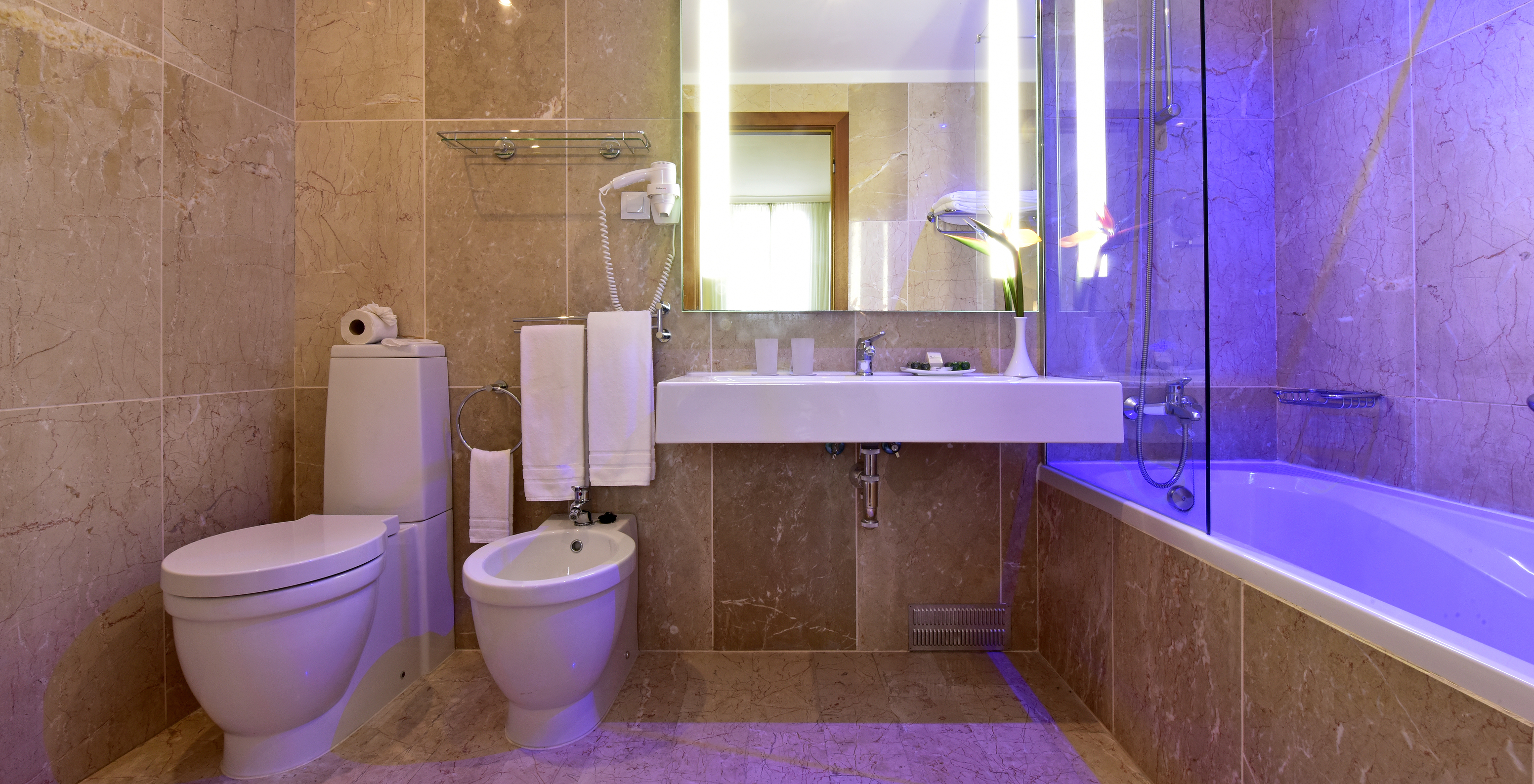 The Deluxe Sea View room at Pestana Viking features a bathroom with sink, mirror, and bathtub with shower