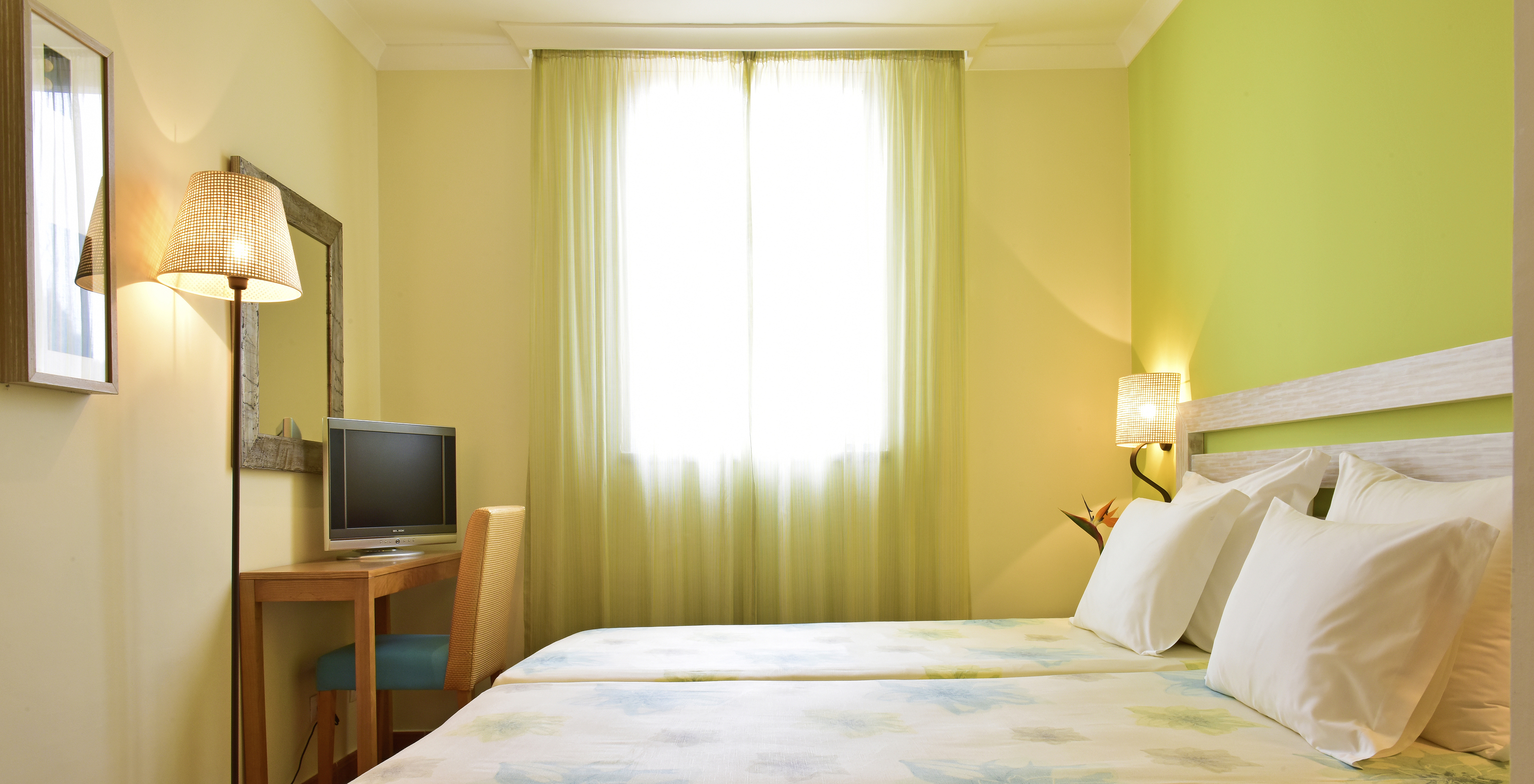 The Suite at Pestana Viking features two single beds with lamp, bedside table, television, and mirror