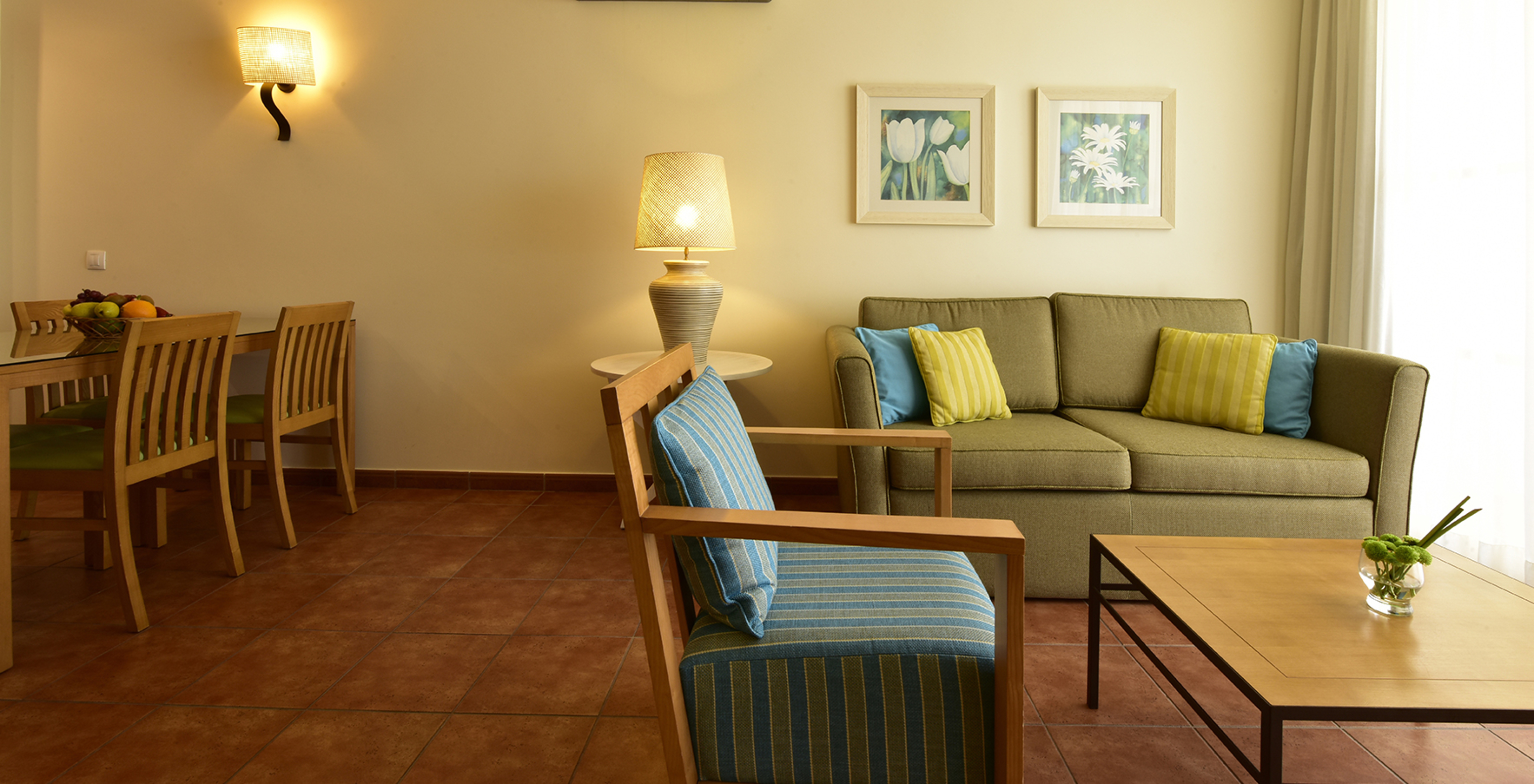 The Suite at Pestana Viking features a green sofa, a coffee table, an armchair, and a lamp