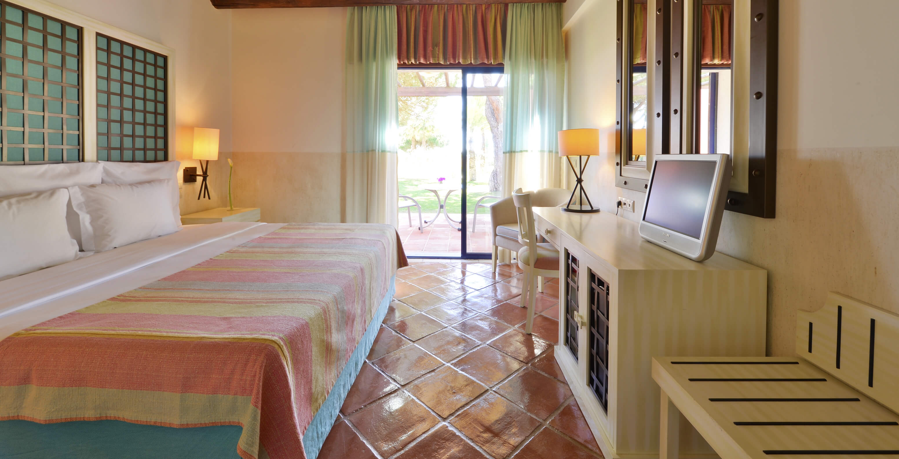 The Garden View Suite at Pestana Vila Sol - Vilamoura has a bedroom with a double bed, mirrors, and a window with a balcony