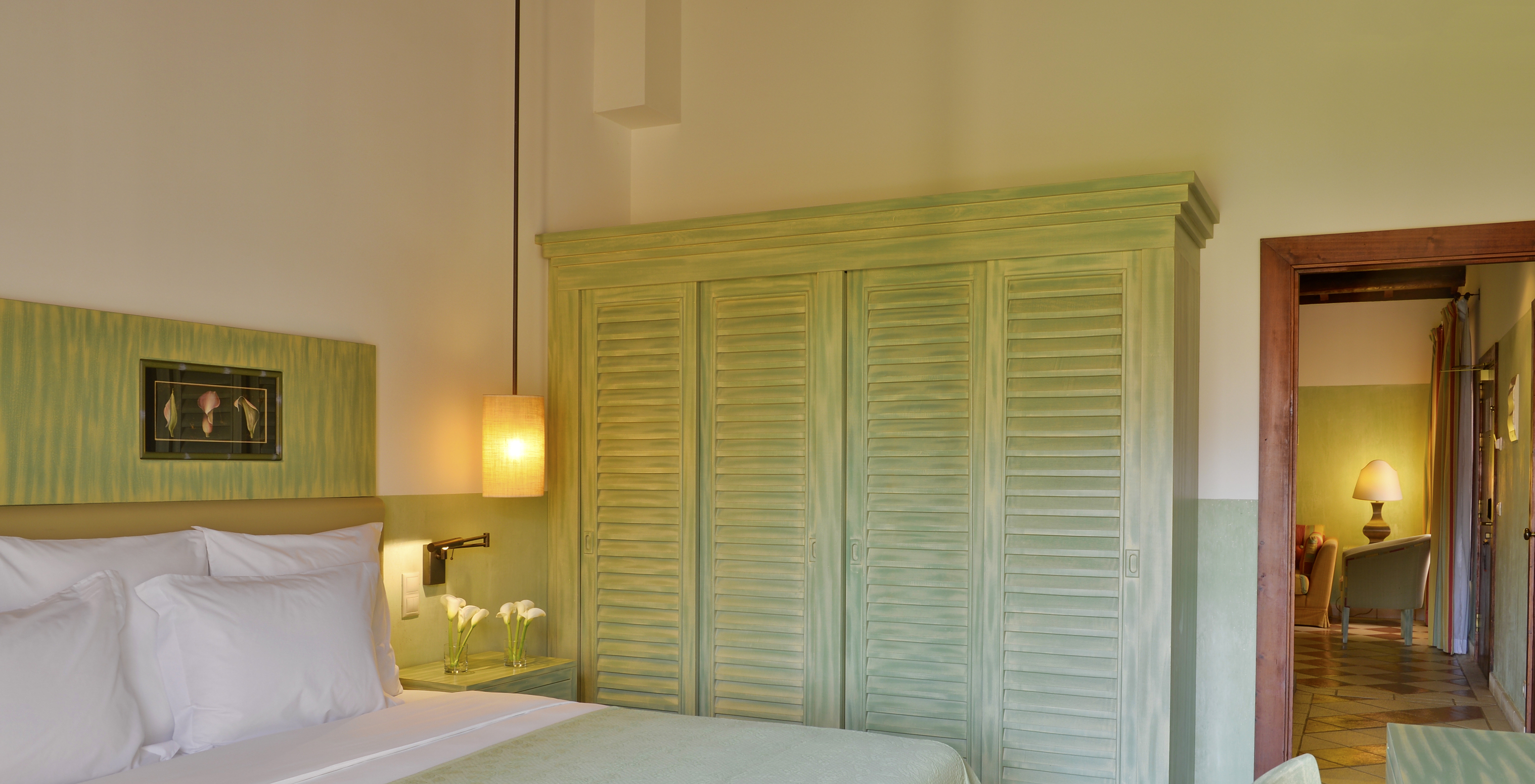 The Superior Garden View at Pestana Vila Sol - Vilamoura has a double bed and a wooden wardrobe in green tones