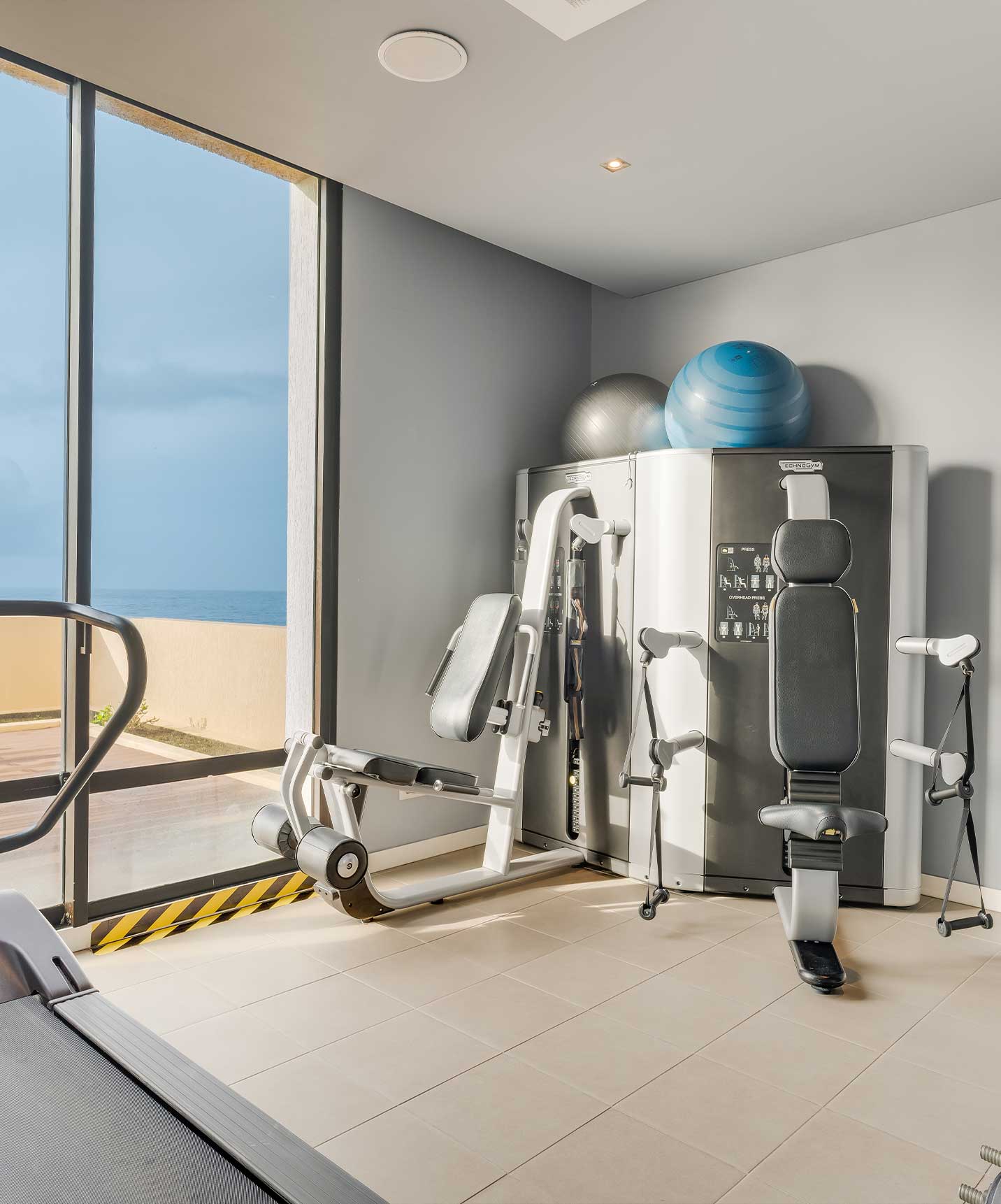 Use the gym at Pestana Bahia Praia with exercise machines, Pilates balls, and sea view